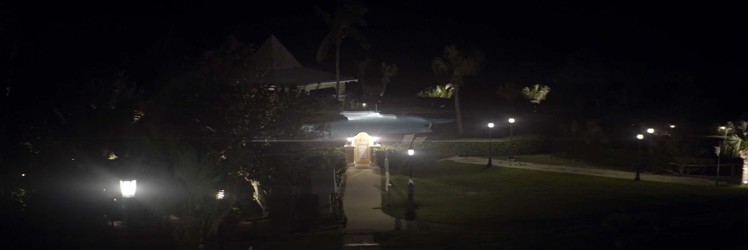 Lomo 50mm squarefront anamorphic | Grotto Bay Beach Resort, Bermuda Islands - f2.5. Here's a nice mix of point source and dim streetlamps, creating a mixture of flare types. Photo by Keith Nickoson.