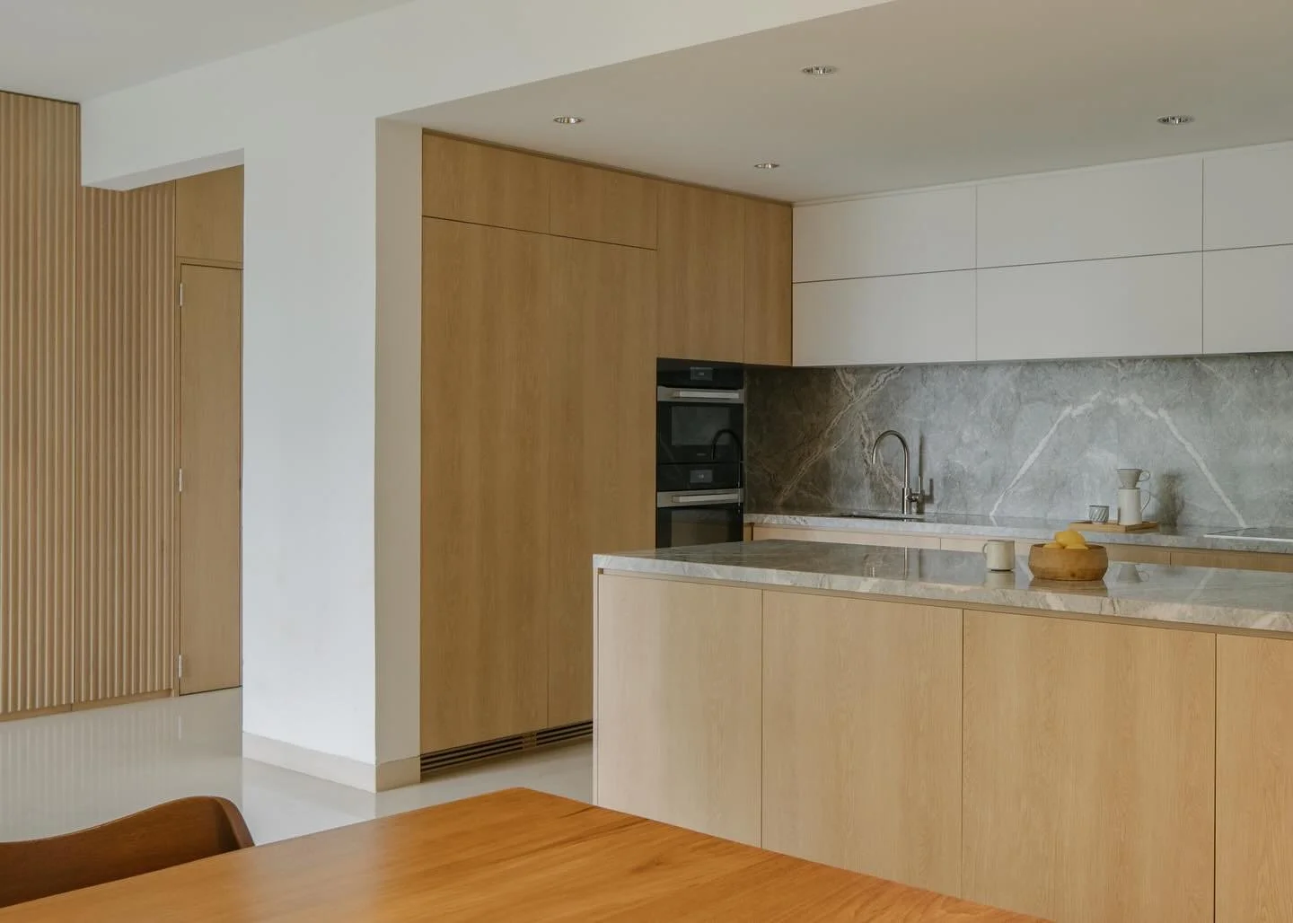 BALMORAL APARTMENT 

The kitchen opens up onto the dining and living room, clad in oak veneer and Fior di Pesco marble.

#takenouchiwebb 
#homedesign 
#sghomedesign 
#sghome 
#singaporehomes 
#sgdesign 
#singaporedesign 
#sginteriordesign 
#sginterio