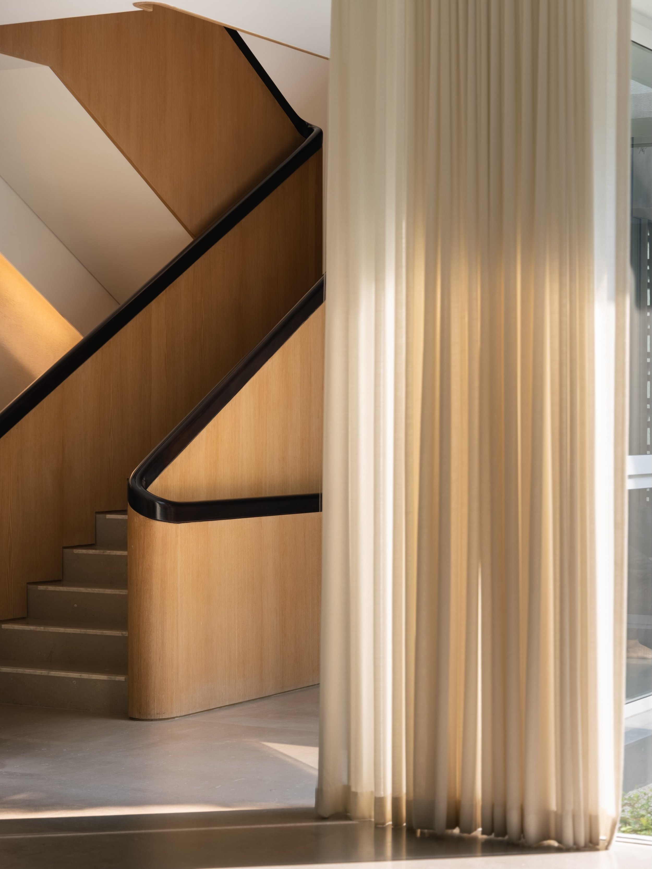 Jakarta Courtyard House

The main staircase is a sweeping sculptural element of light timber veneer with a solid dark timber hand rail and grey stone steps with a contrasting white marble edge.

Photography: @kungphotograph 
Landscape: @thishumidhous