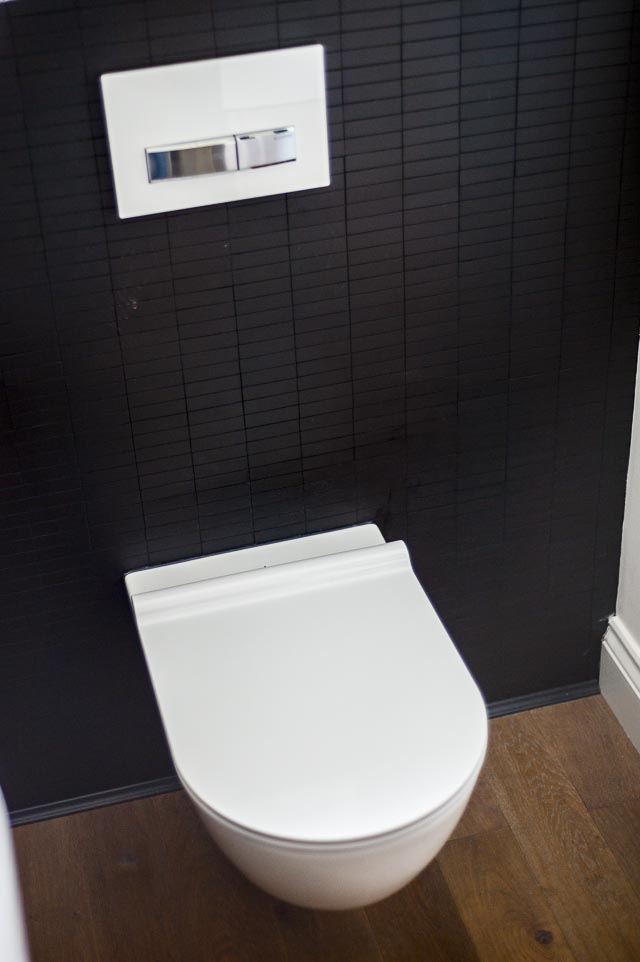 Wall Hung Toilet against Black Tiled Wall
