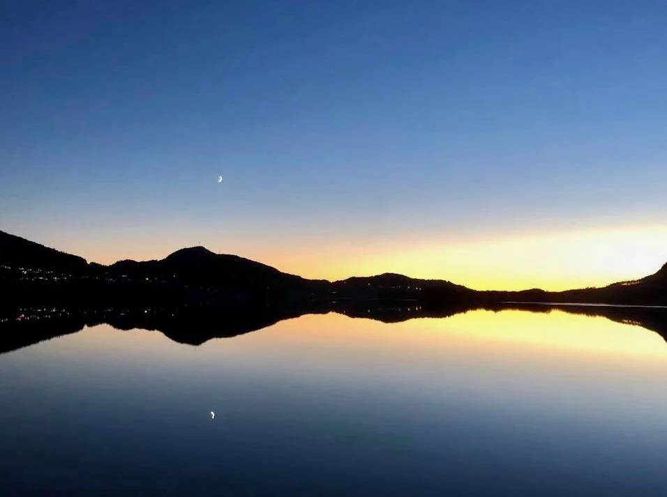 Astri S. Måkestad har òg lete seg fascinera over den fine dagen og kvelden, og ein måne på veg opp. Han speglar seg endåtil i eit blikkstille Opsangervatn.