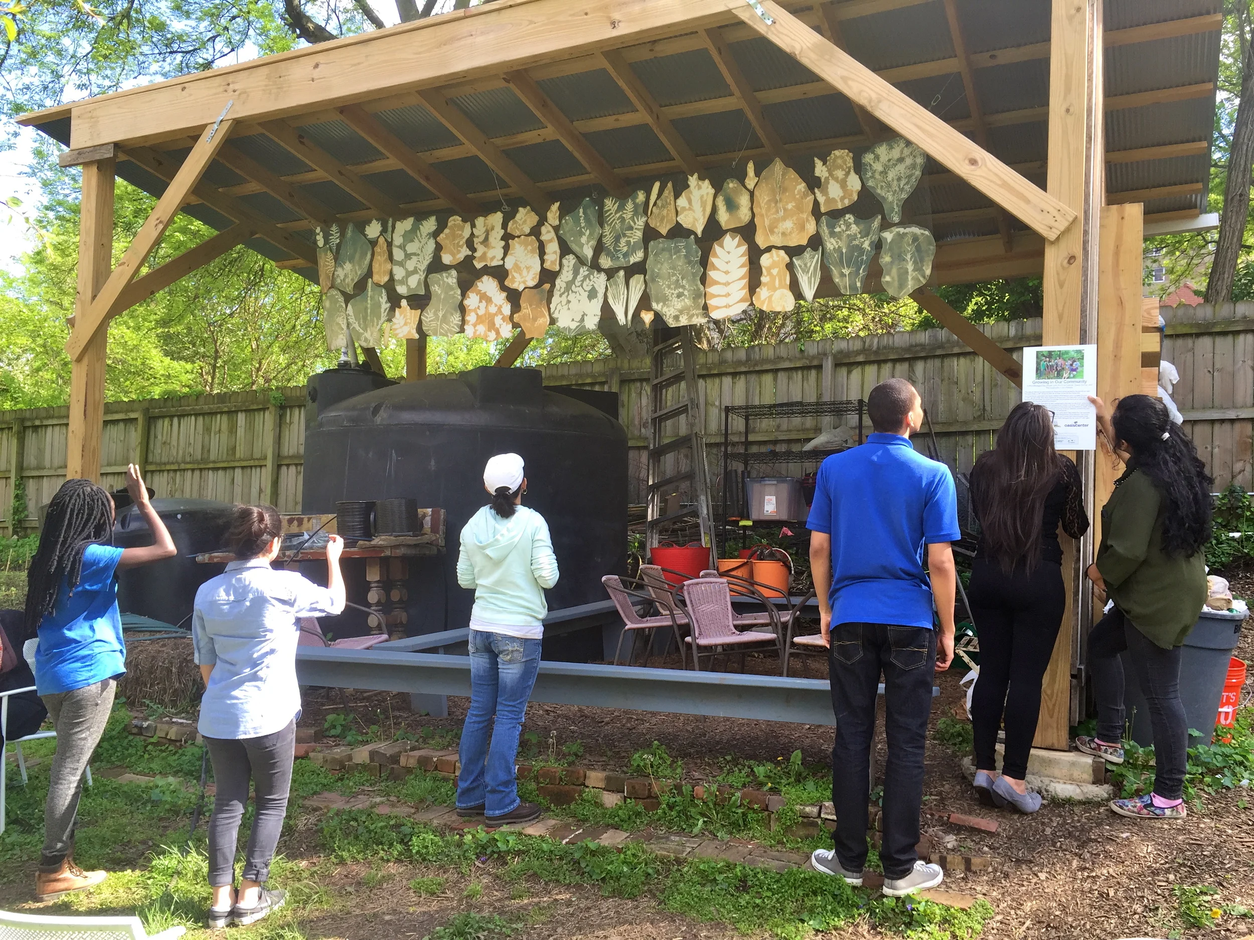 Last summer, students from the Oasis Center worked in partnership with The Frist Center to make this beautiful art installation that hangs over the refugee toolshed at our Wedgewood Urban Gardens. Some of the students continue to volunteer weekly in the garden and are proud to show their artwork to their peers from the International Teen Outreach Program.