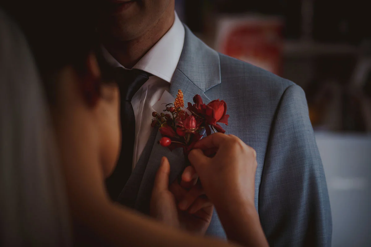 unique red and yellow buttonholes with wild flowers and berries for a London Wedding