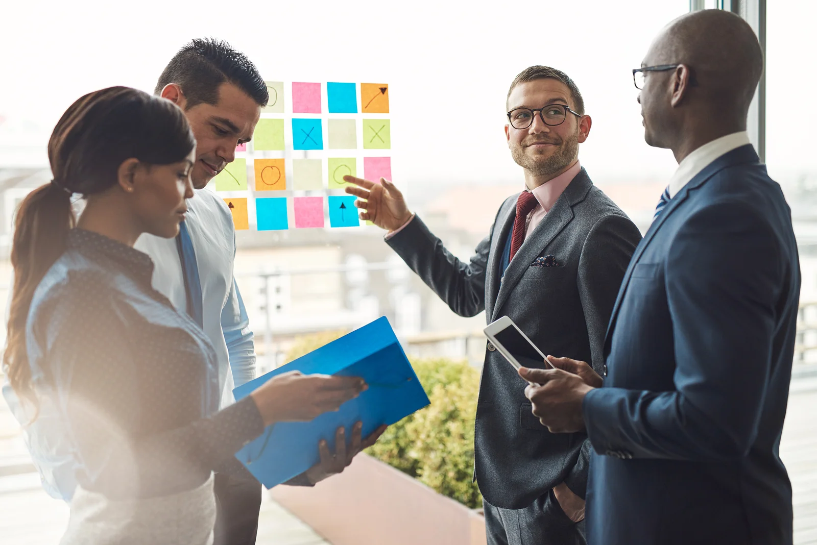 Group Of Business People With Notes On Window