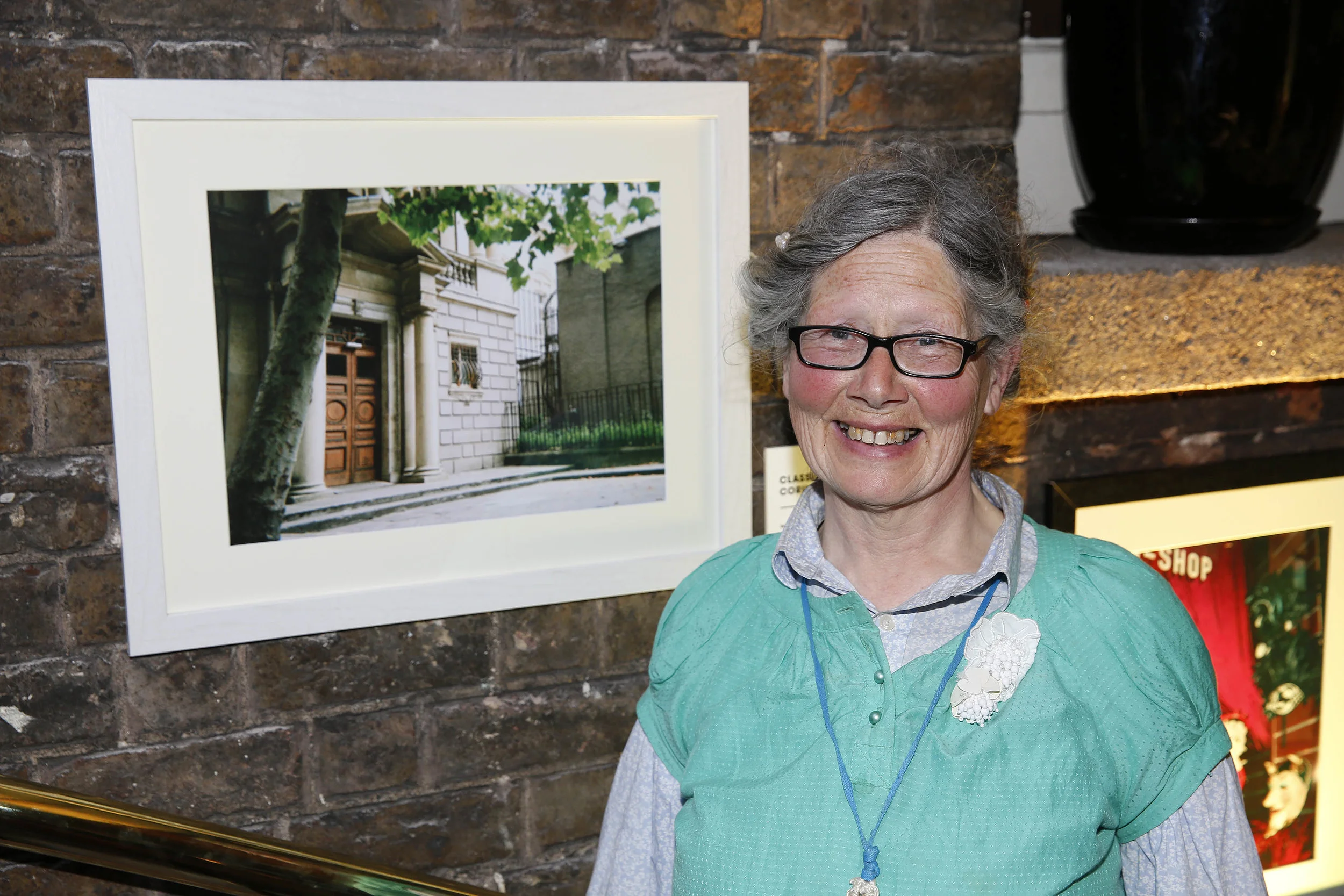 One of our IN SIGHT photographers Ramblin' Rose beside her photograph 'Classical Doors with Corinthian Pillars.'