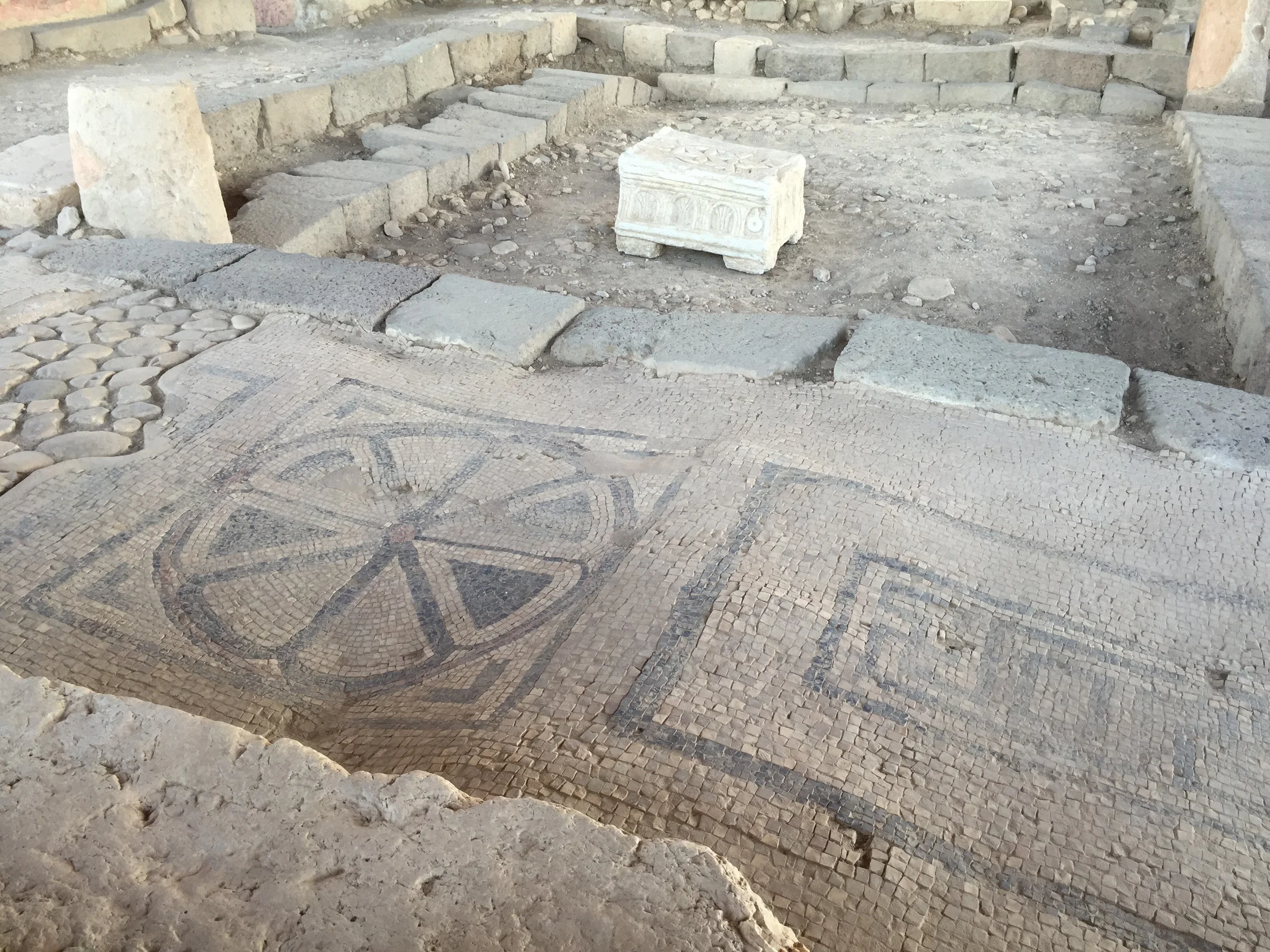This picture is from the back of the synagogue facing the entrance. On the floor behind the replica Magdala Stone is beautifully preserved 1st century tile work.