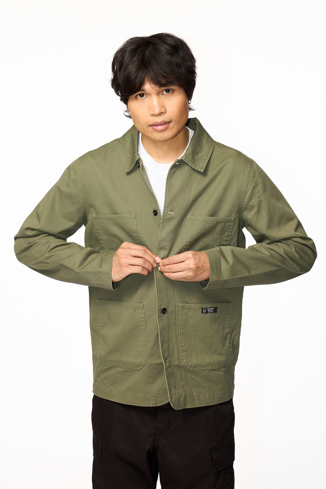 Green chore jacket close-up showing button closure and fabric texture