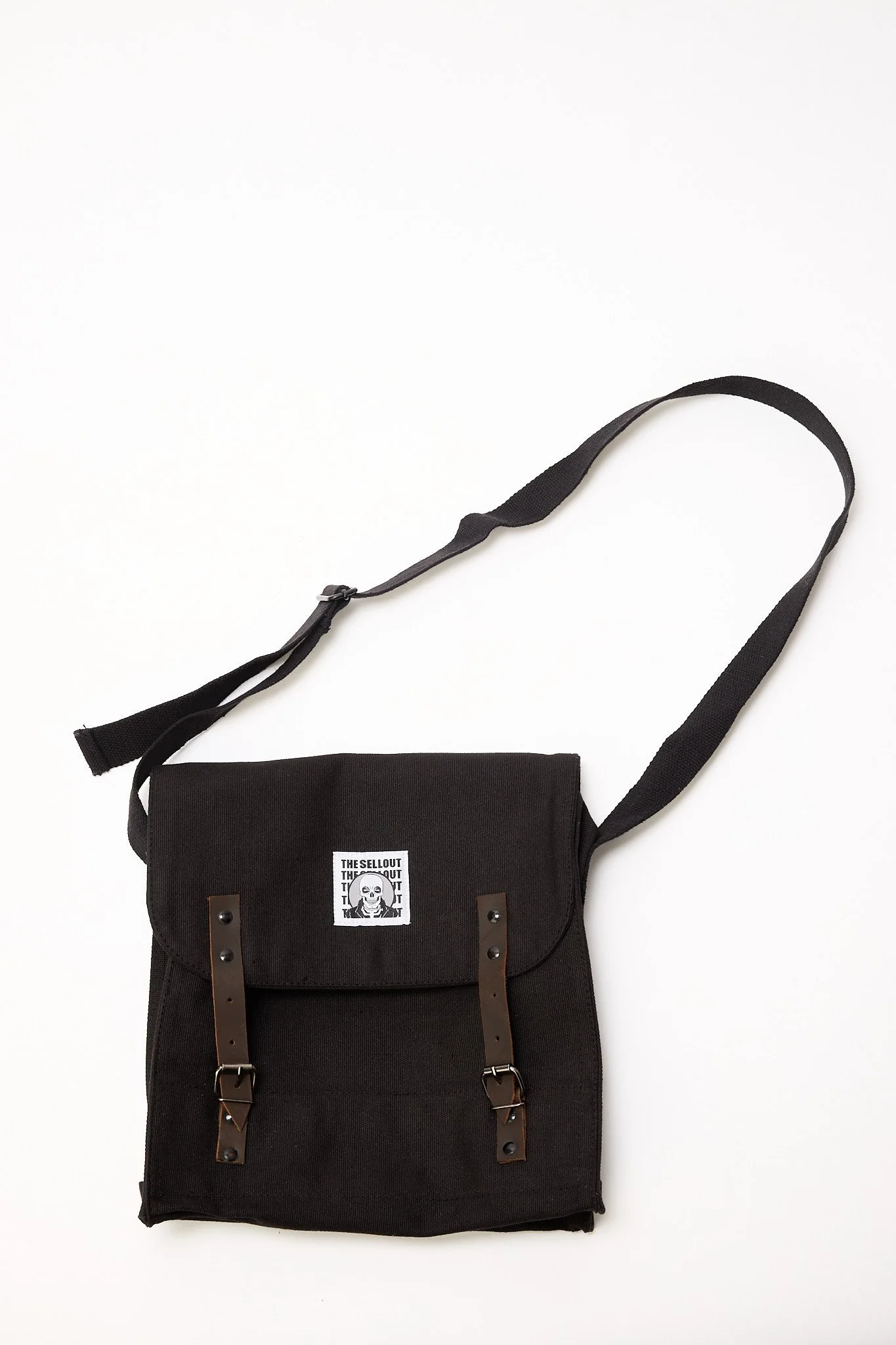 Black canvas shoulder bag front view showing buckle straps and structured mid size design