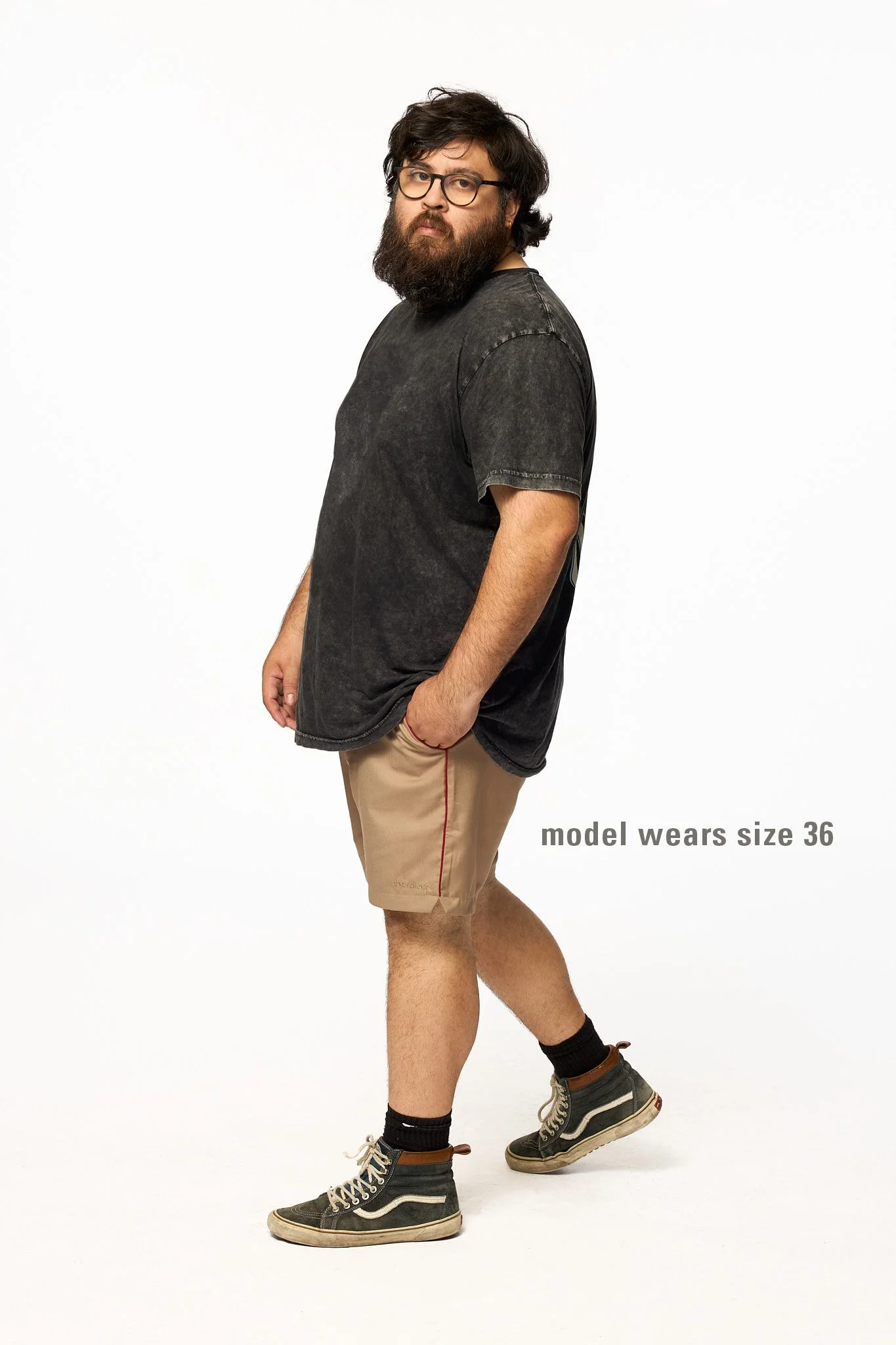 Khaki piped shorts full body walking with relaxed fit and red contrast piping detail