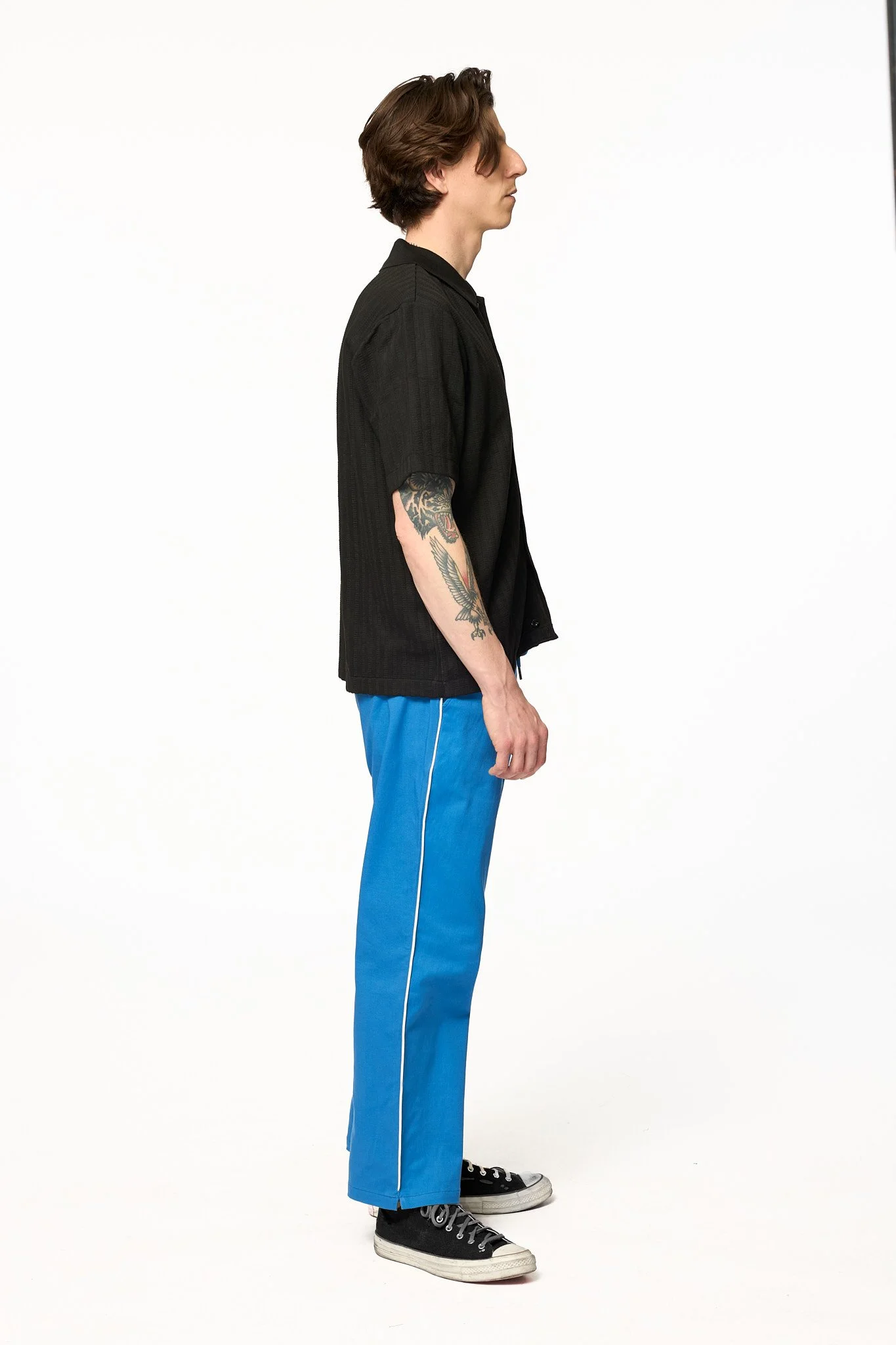Royal blue piped pants by The SellOut side profile view showing white contrast piping and relaxed fit