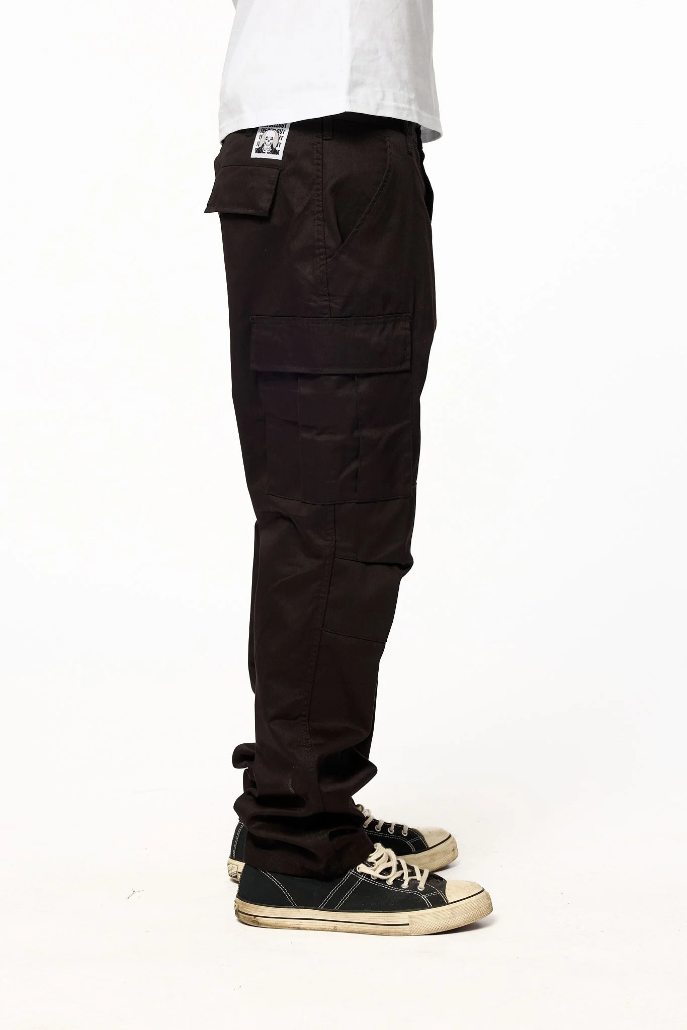 Black cargo pants side detail showing large utility pocket and stitching