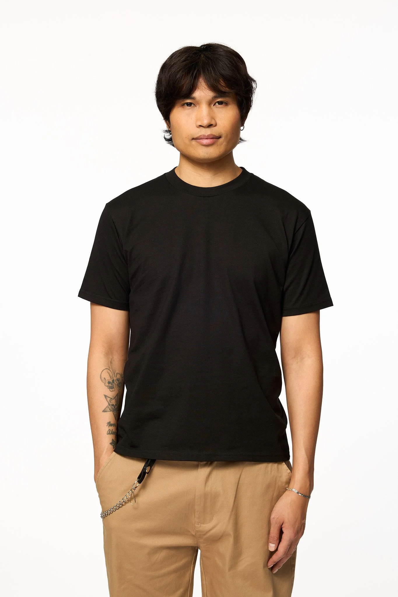 Model wearing The SellOut Heavyweight Short Cut Tee in black with a clean heavyweight cotton fit and slightly shorter body.