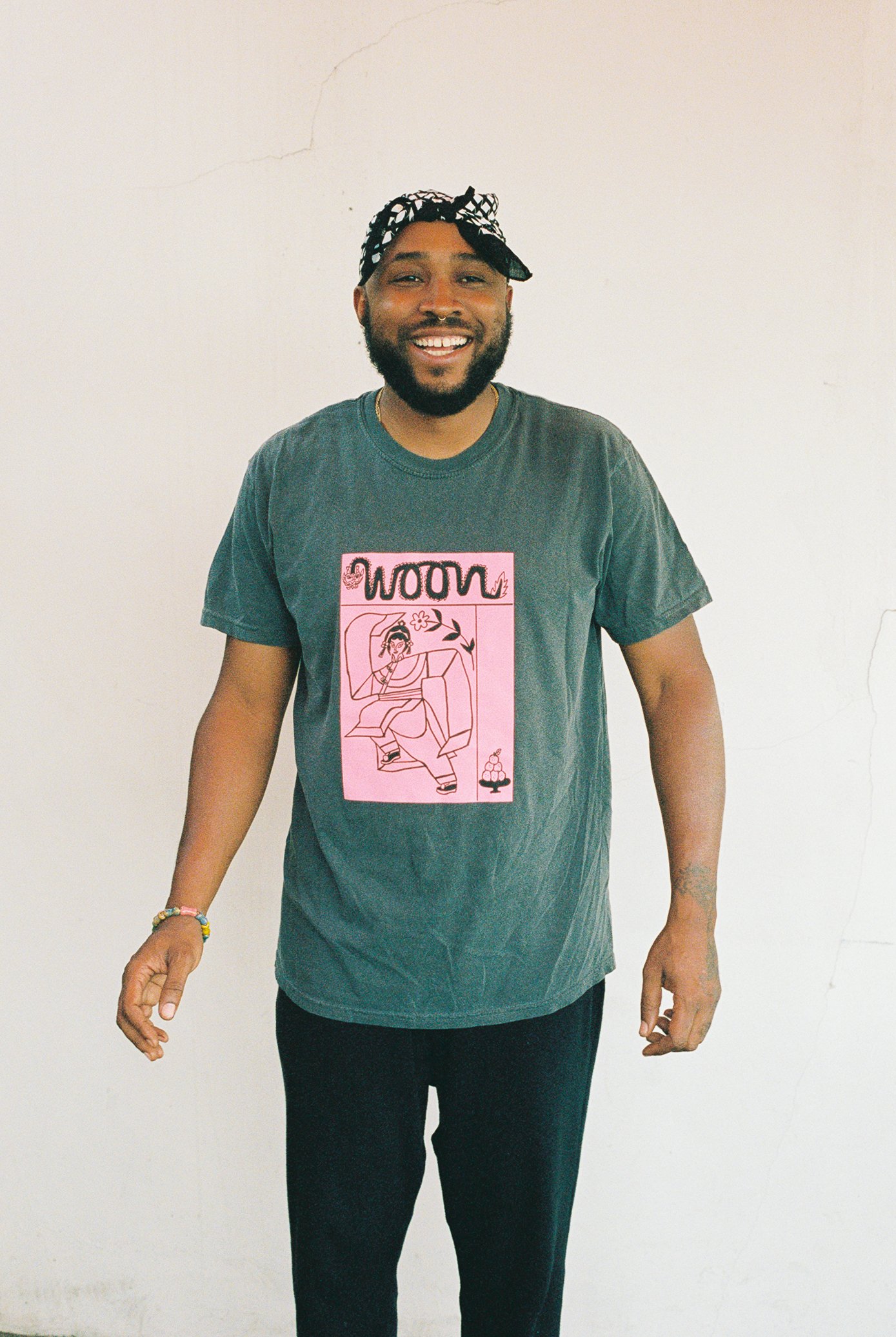 Someone wearing a faded black t-shirt with pink artwork