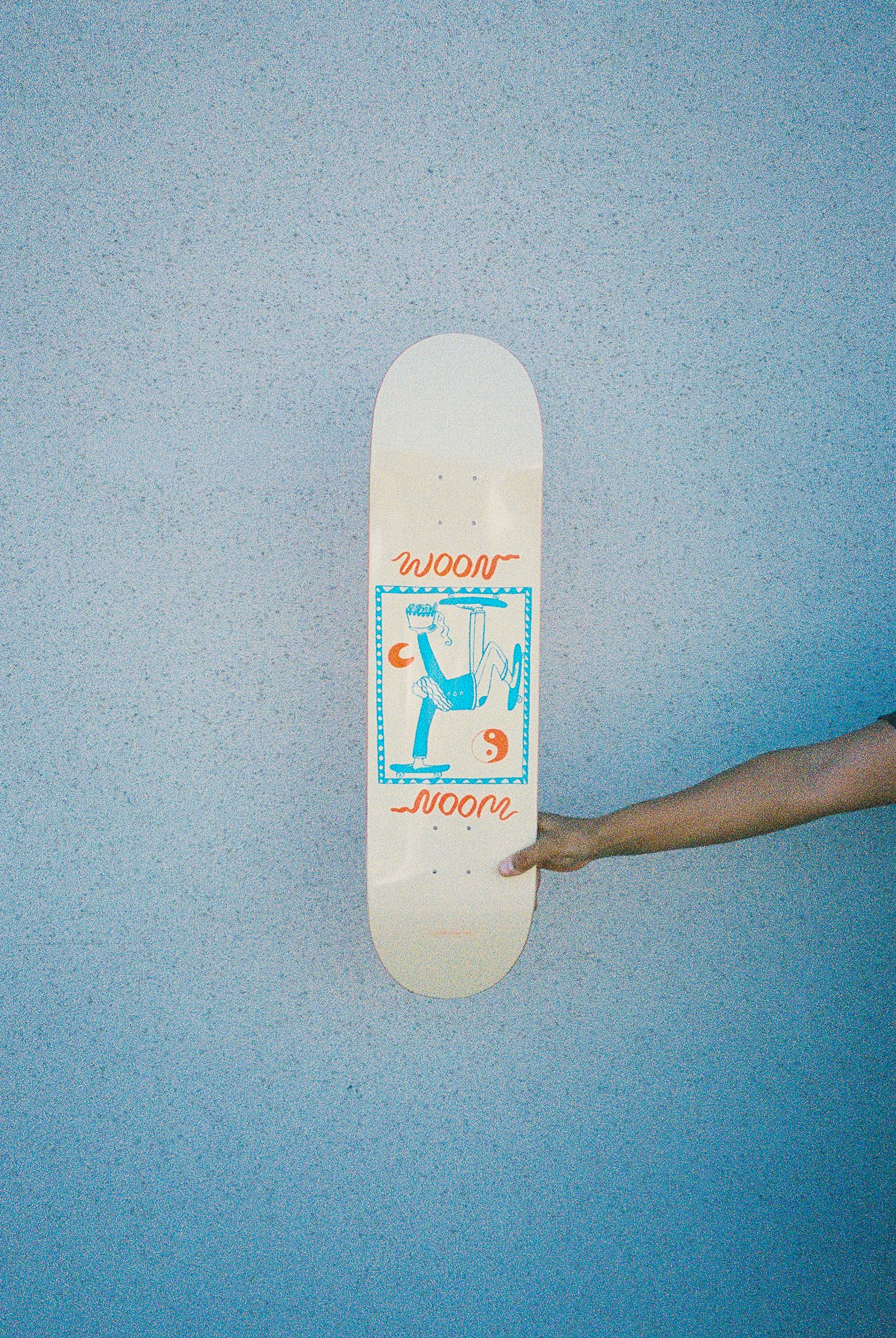A hand holding a skateboard deck