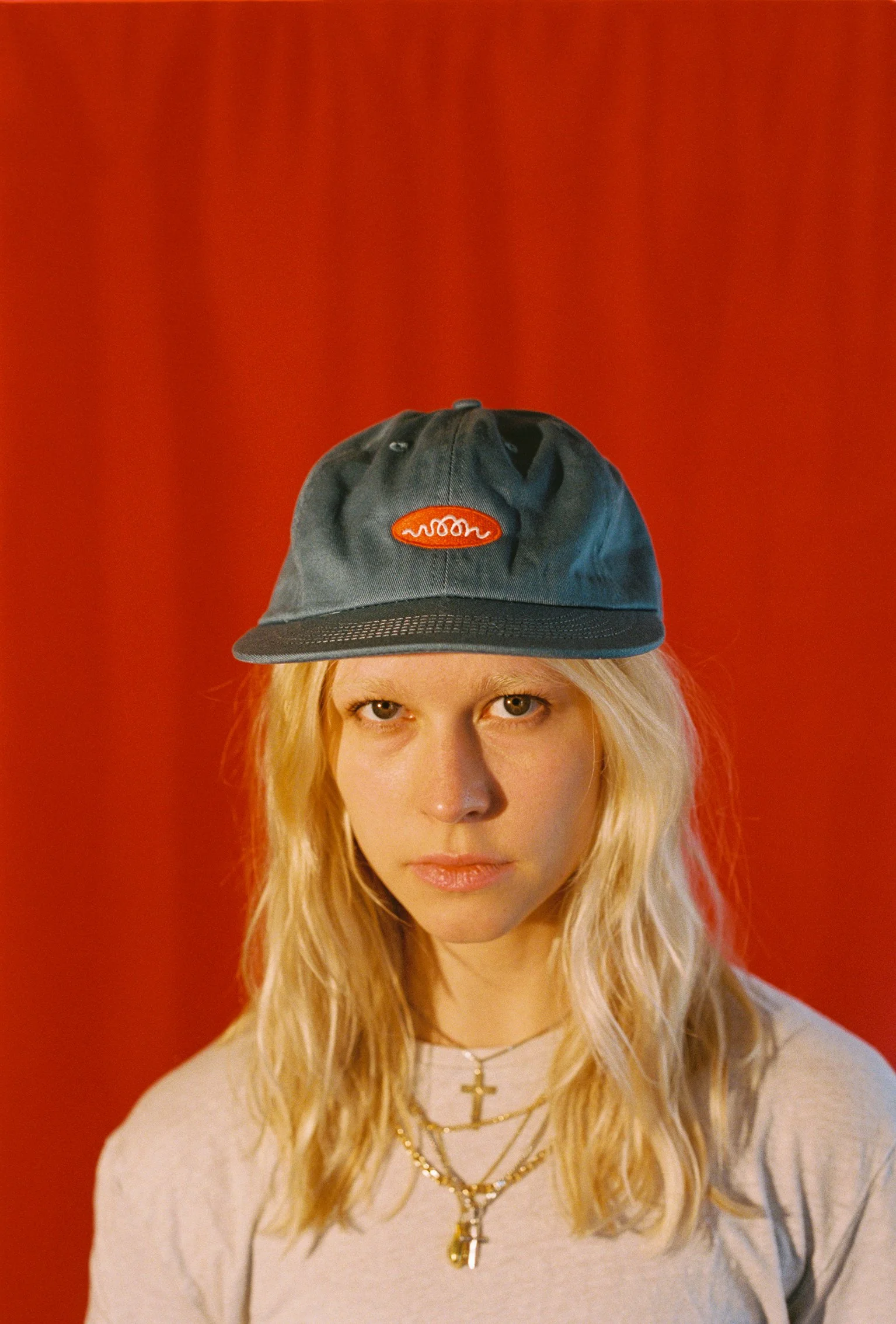 A person wearing a blue flat bill cap with Woon logo