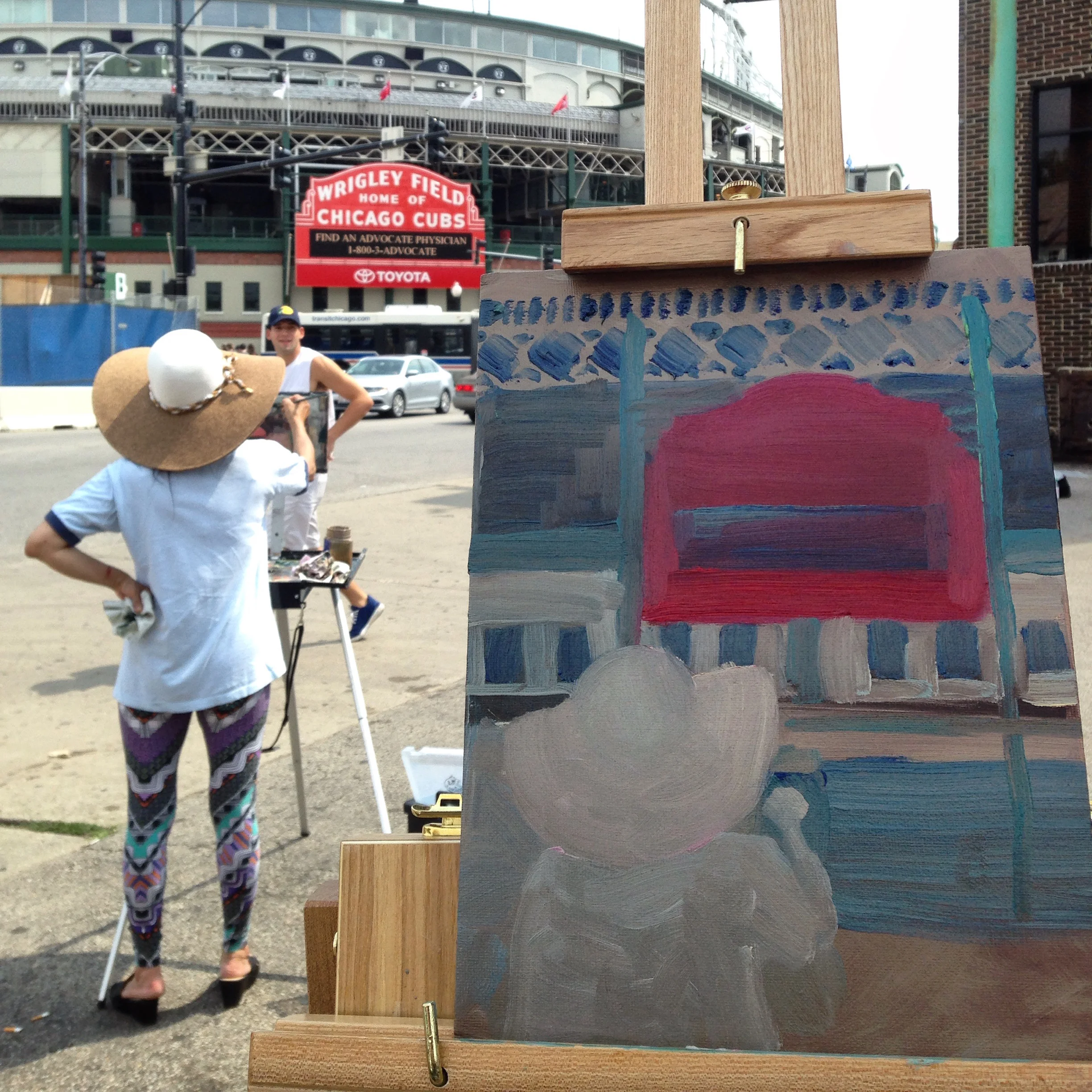 Work in progress shot of my Wrigley Field painting, with my fellow painter in the foreground. Included in this photo: friendly jogger checking us out as he went by. Not included: LOTS of folks in red shirts coming to Wrigleyville for the #MoustacheCrawl.