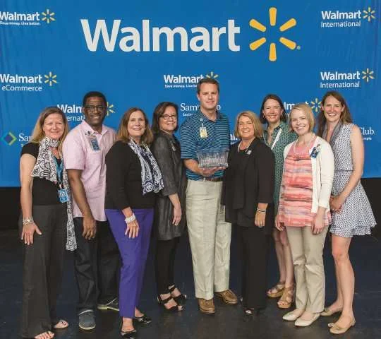 Walmart President and CEO Douglas McMillon, center, received WBENC’s Crystal Leadership Award from WBENC President & CEO Pamela Prince-Eason, fourth from right, on June 6, 2015 during Walmart’s Saturday Morning Associate Meeting as part of the annual shareholder’s meeting. Photo: WE USA