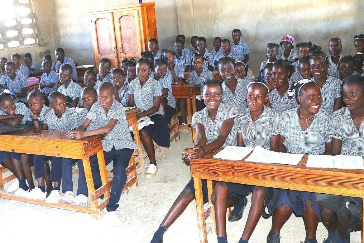 Students share desks at Haiti EcoVillage School.