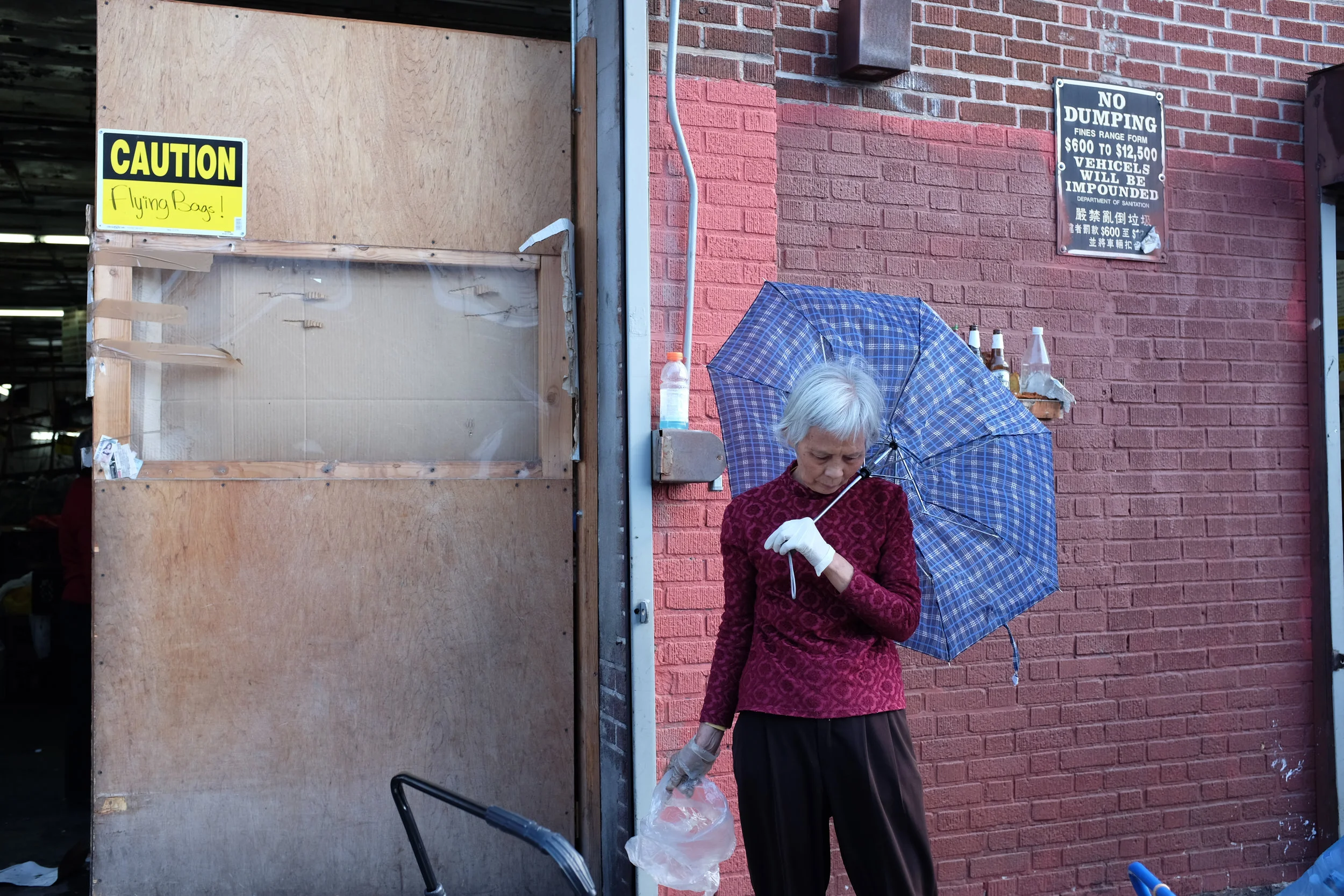 A woman pauses to take a break from her work in front of the recycling center. 