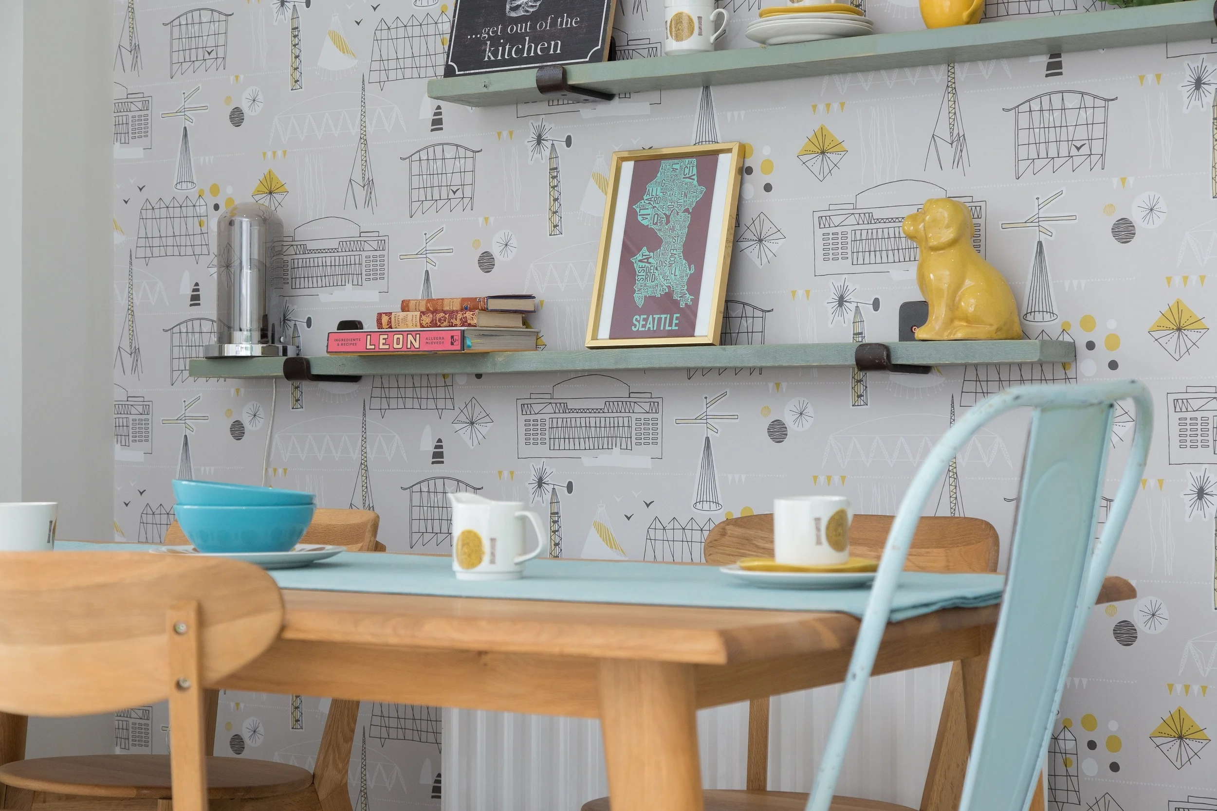 Retro wallpaper forms a quirky backdrop to an eclectic array of accessories, displayed on hand made wood and metal shelving.