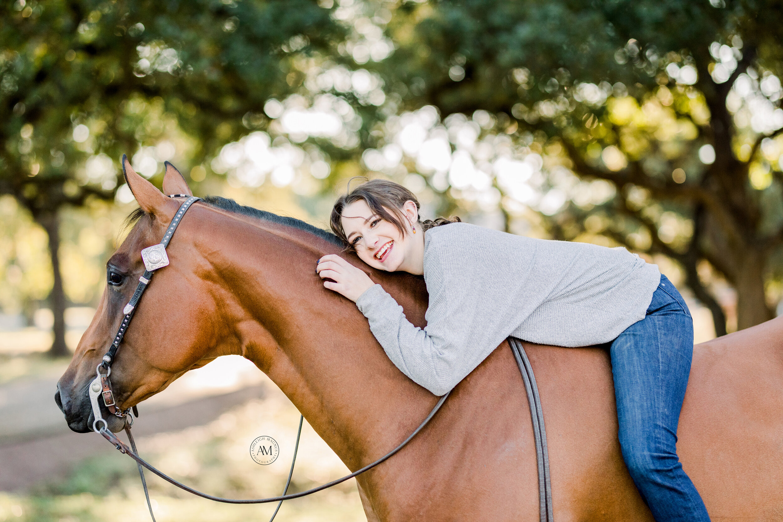 Smiling girl on her bay horse 