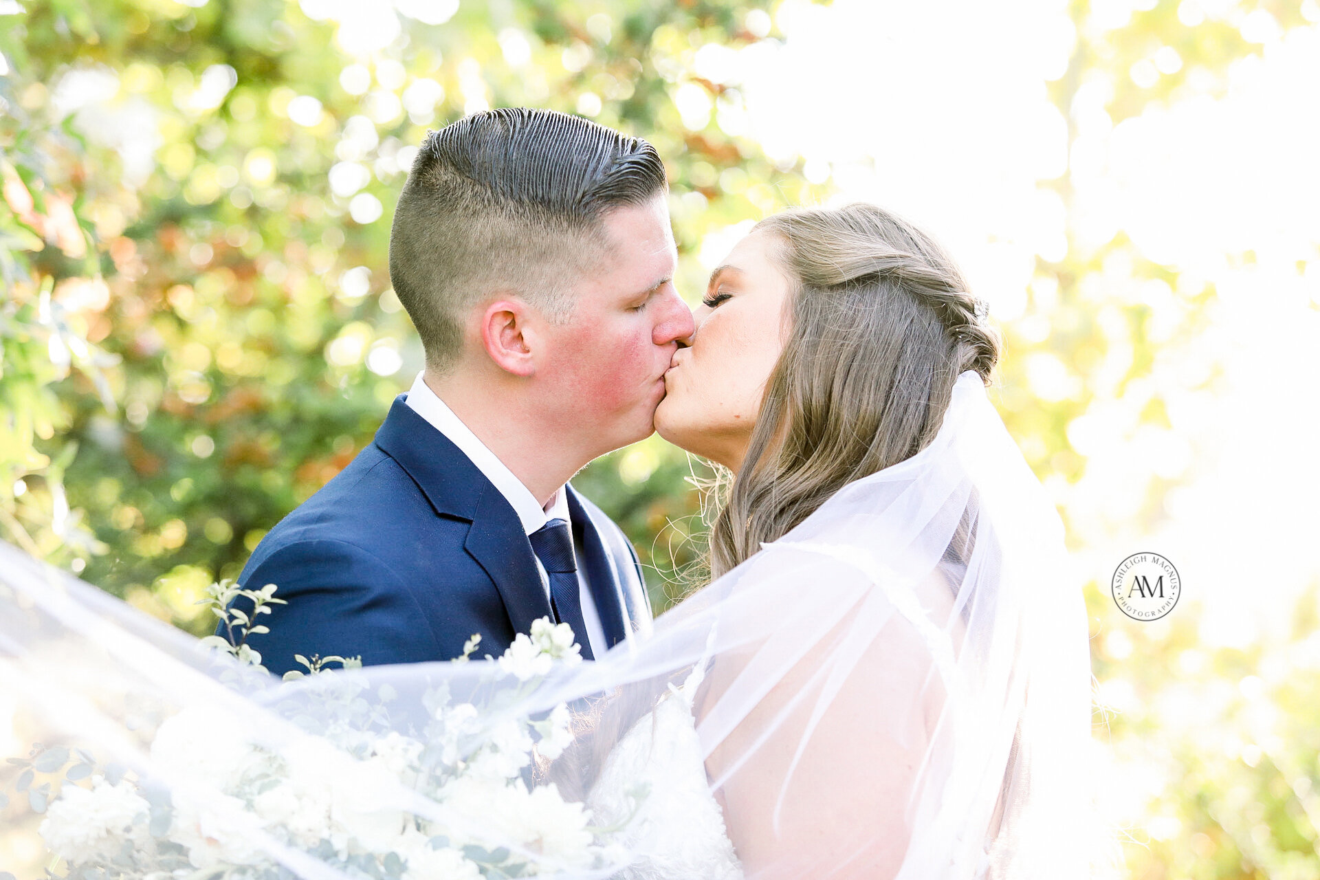 bride and groom kissing with veil 