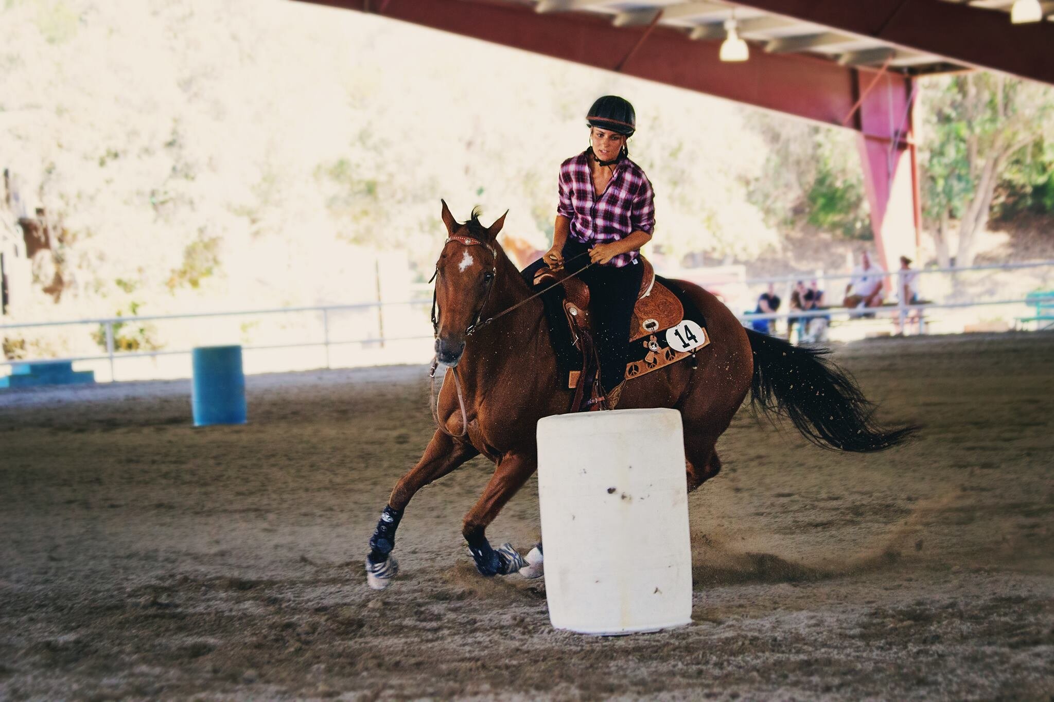 Girl barrel racing on a bay horse