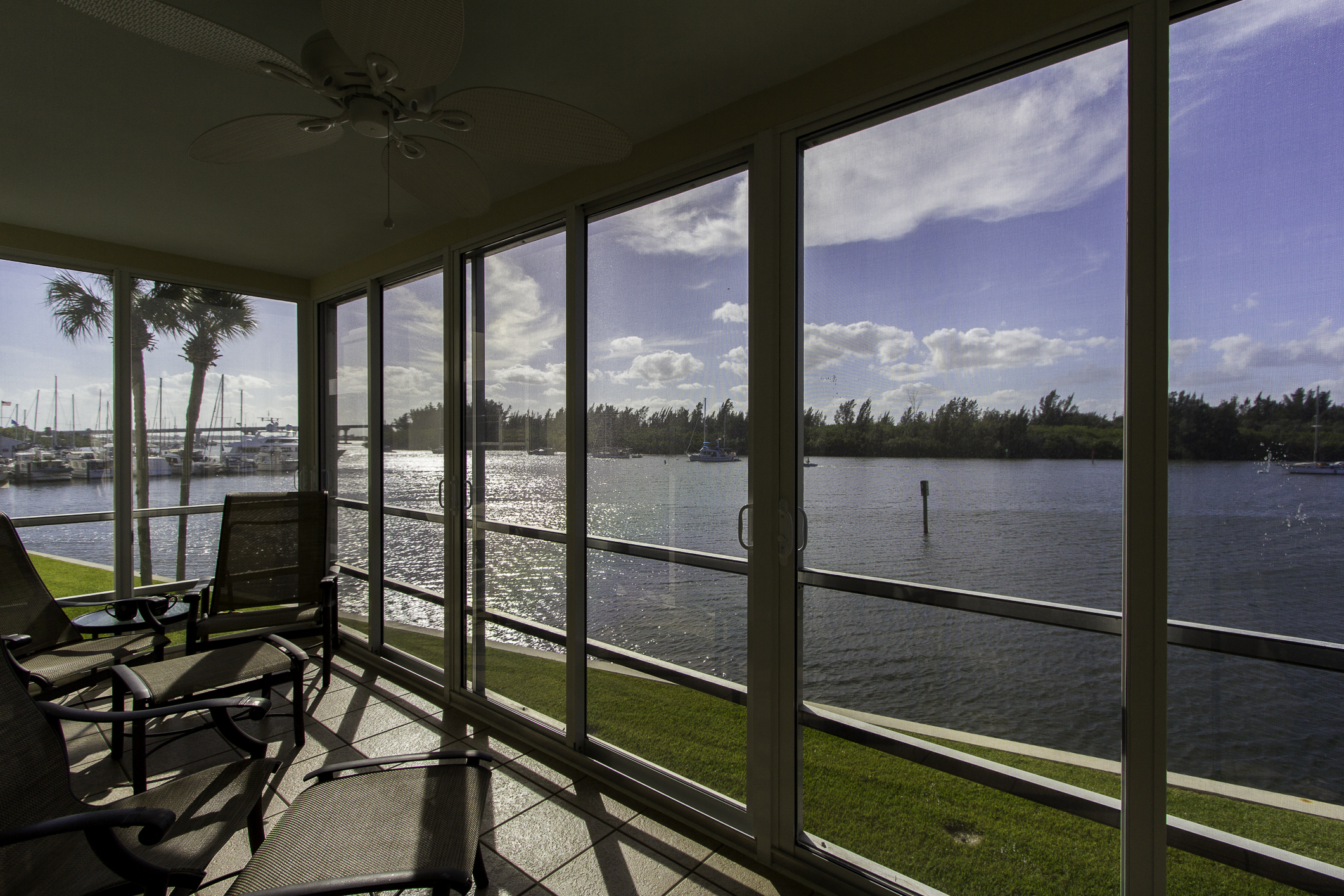 A covered and screen enclosed porch looking out onto the Indian River.