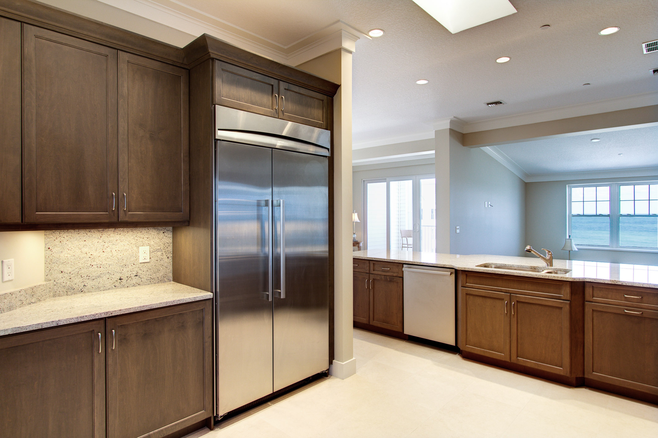 Modern kitchen update at the Gables with stone countertops, stainless steel fridge and ocean views