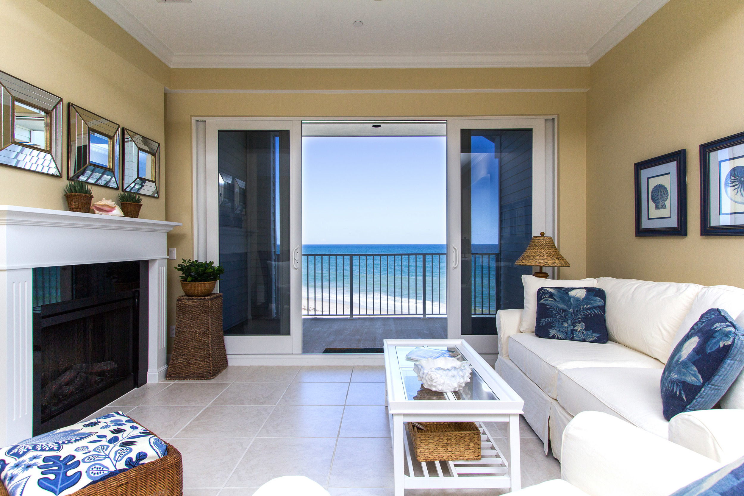 Living Room features see through fireplace and glass sliding doors opening to an oceanfront balcony
