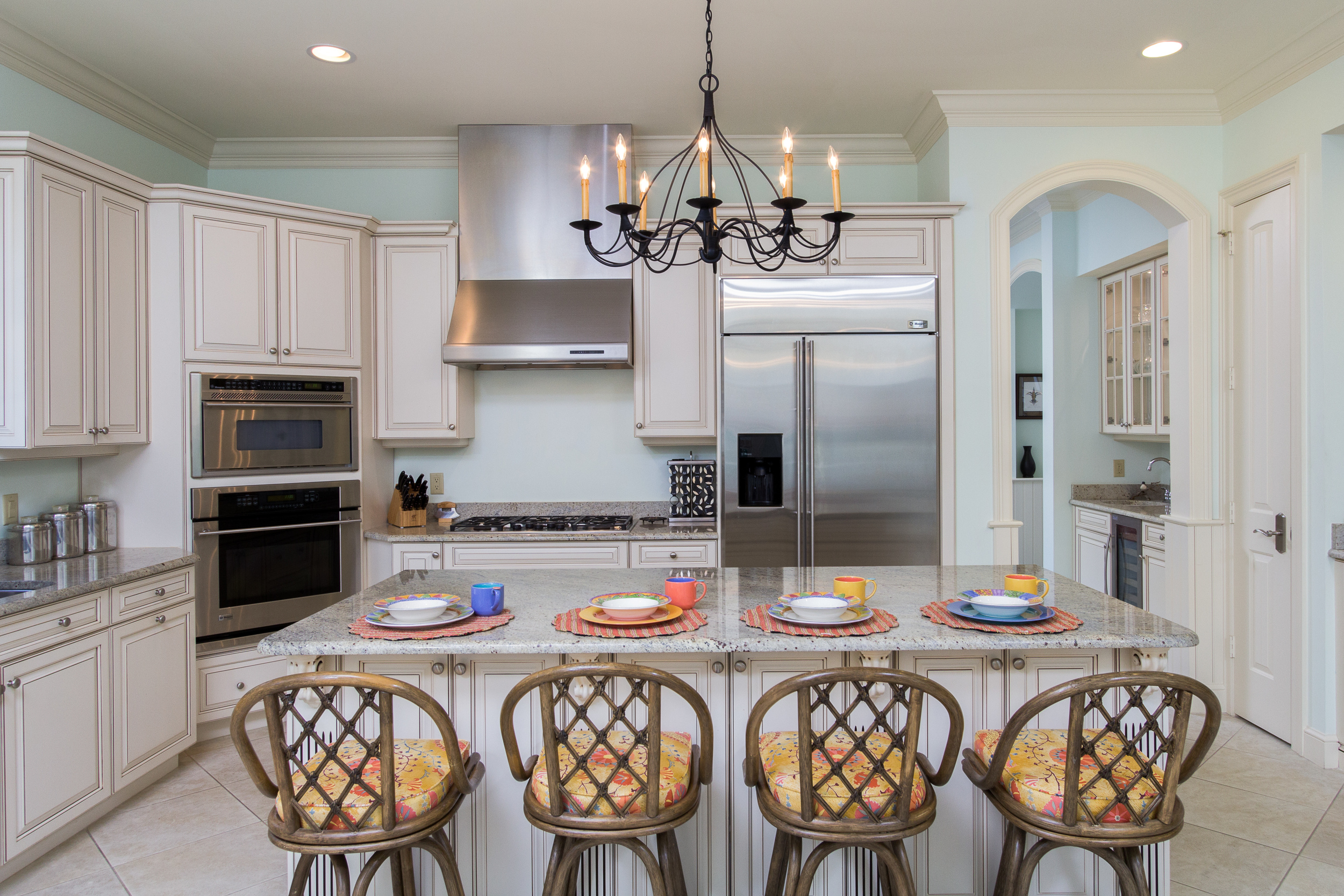 Luxurious island kitchen with stone counters and stainless steel appliances.