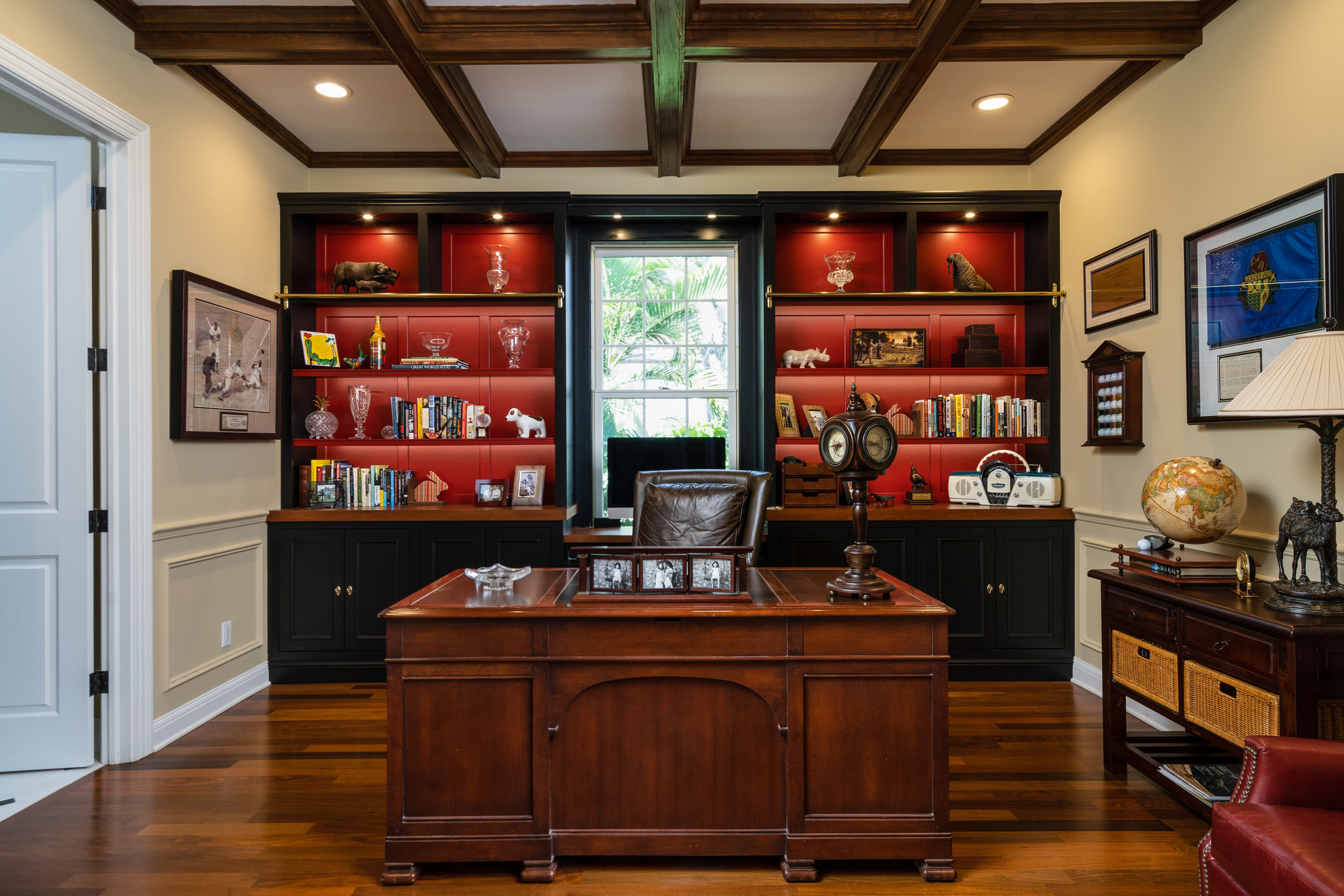 Beautiful home office with exposed beam coffered ceilings and built-in shelves