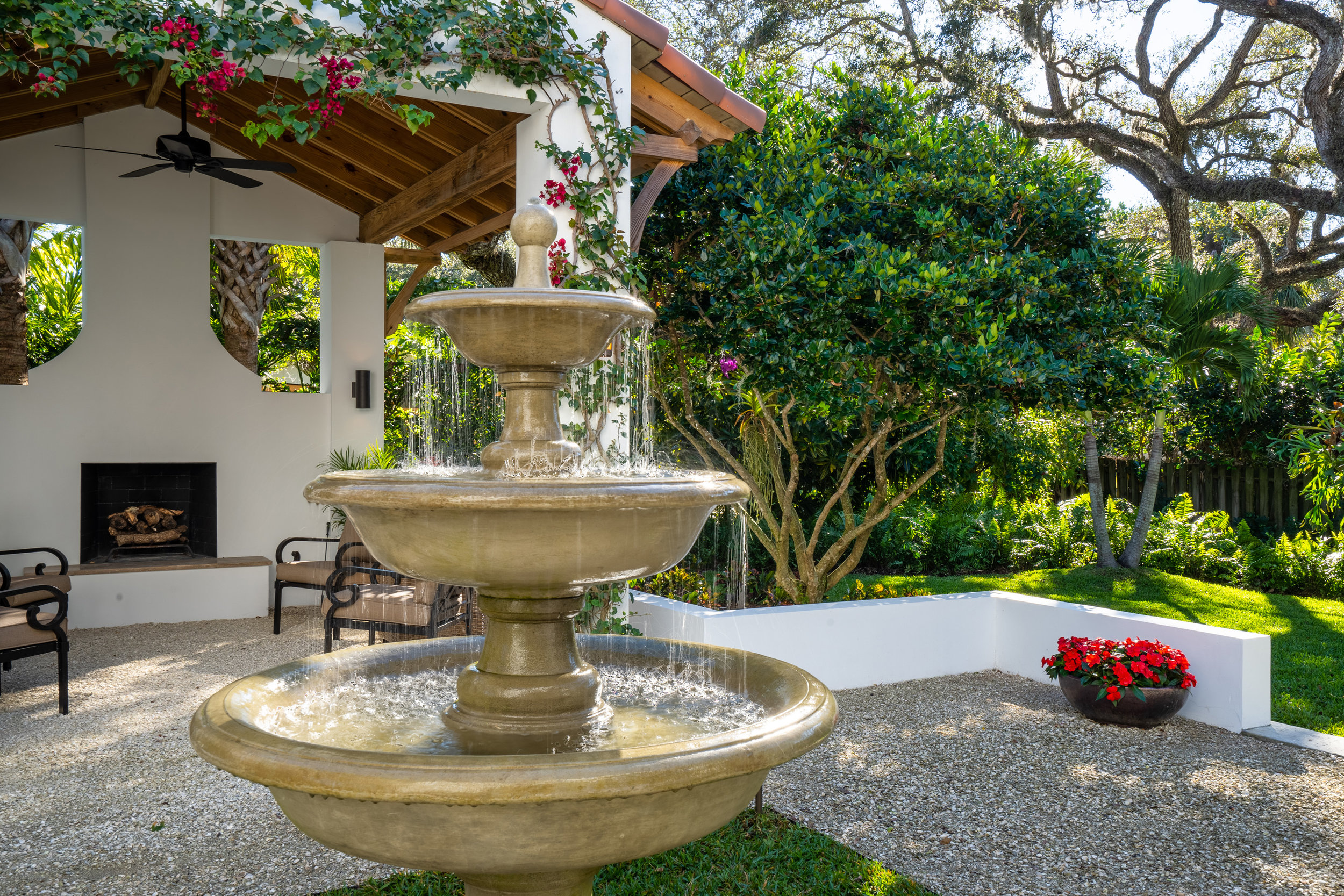 Decorative fountain in serene backyard of this luxury home.