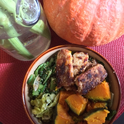 Honey Sesame Tempeh served over sautéed greens with kabocha squash + kraut