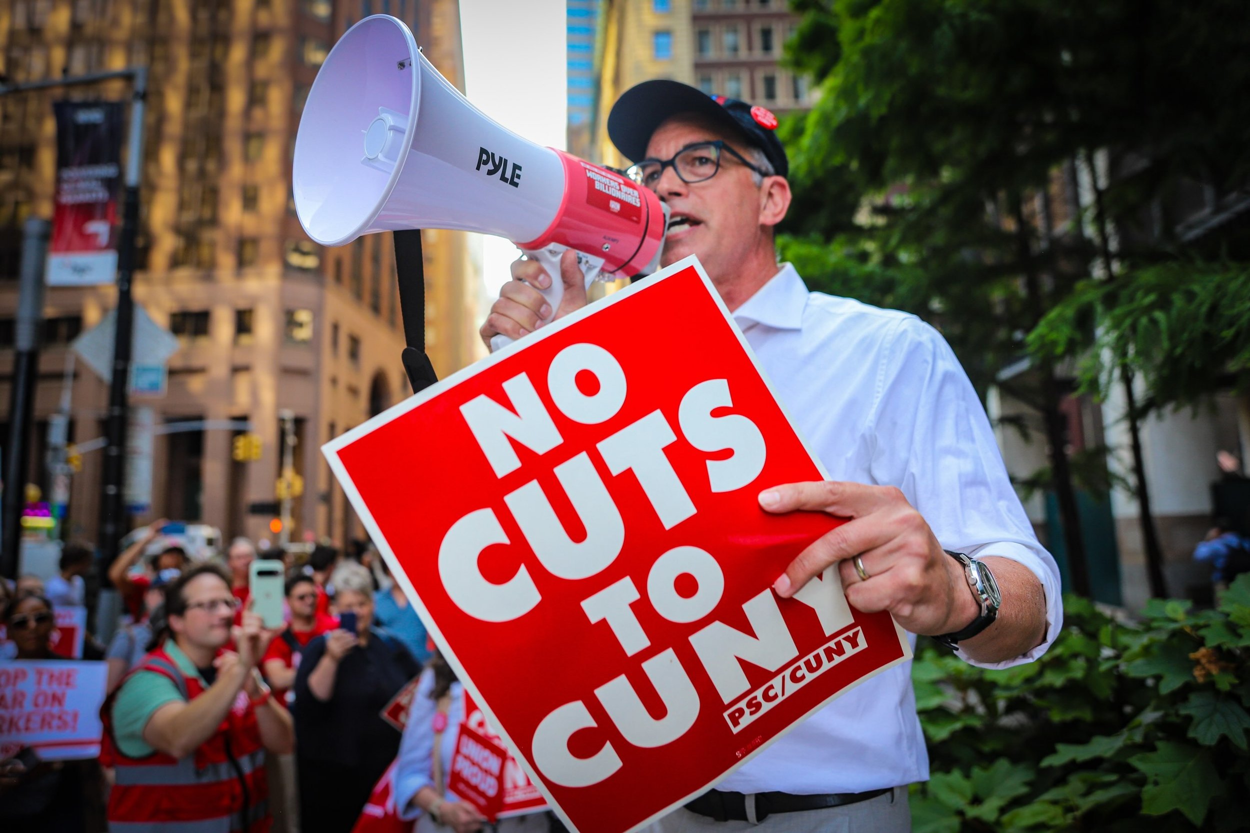 Nearly 100 faculty, students, and staff from Queens College and CUNY&rsquo;s PSC picketed outside the Wall Street investment bank where CUNY Board of Trustees Chair William Thompson works to protest departmental budget cuts and layoffs of part-time f