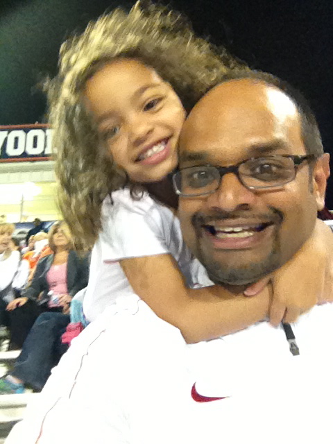 Roy taking in the weekly high school football game with his girls.