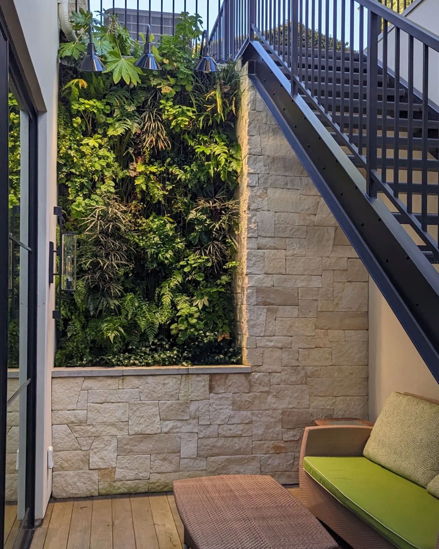 Create mood and ambience with a lush green living wall integrated with architecture for this intimate space. @florafelt living wall by @plantsonwalls.