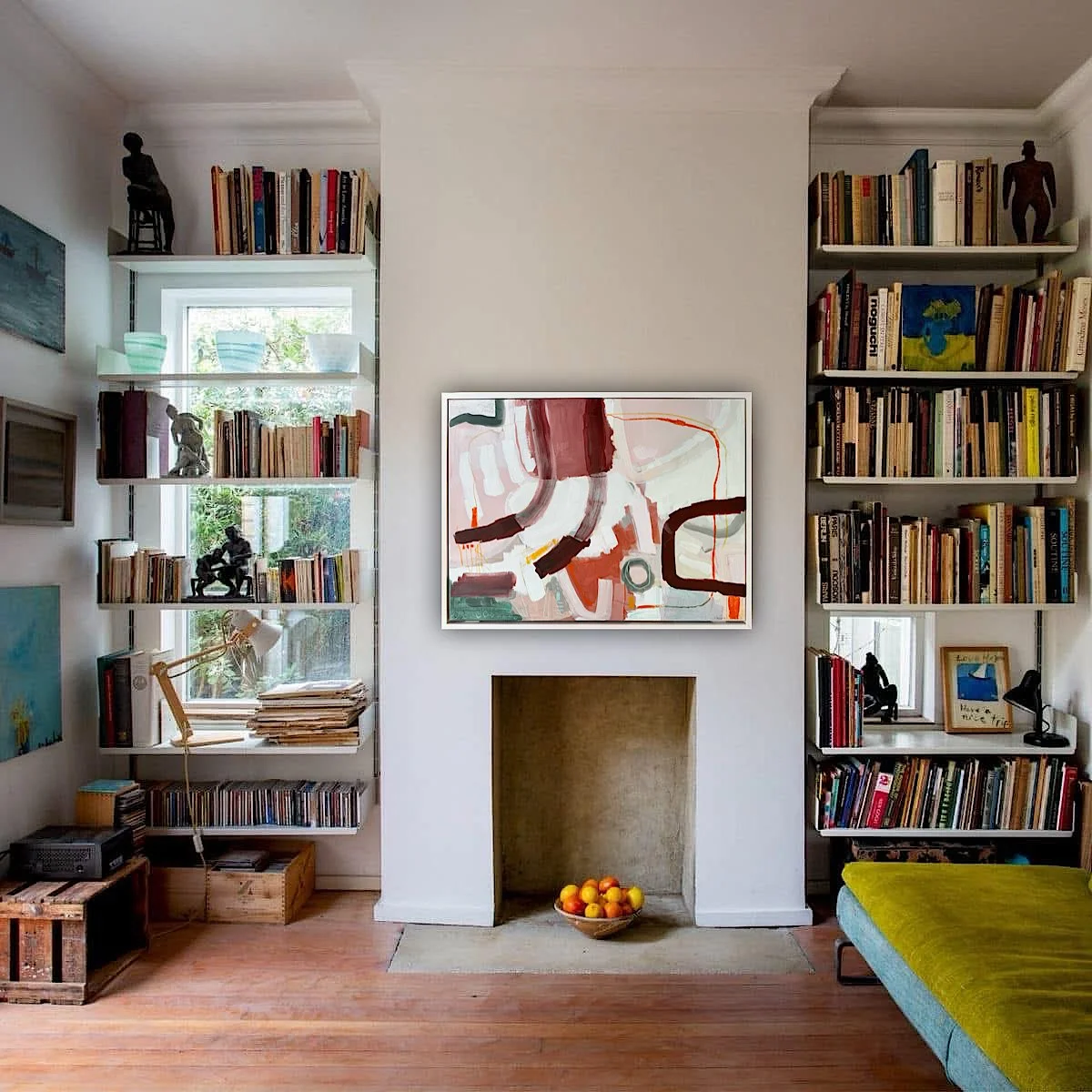 light pink framed abstract painting with brown lines and forms hanging on a cozy living room wall