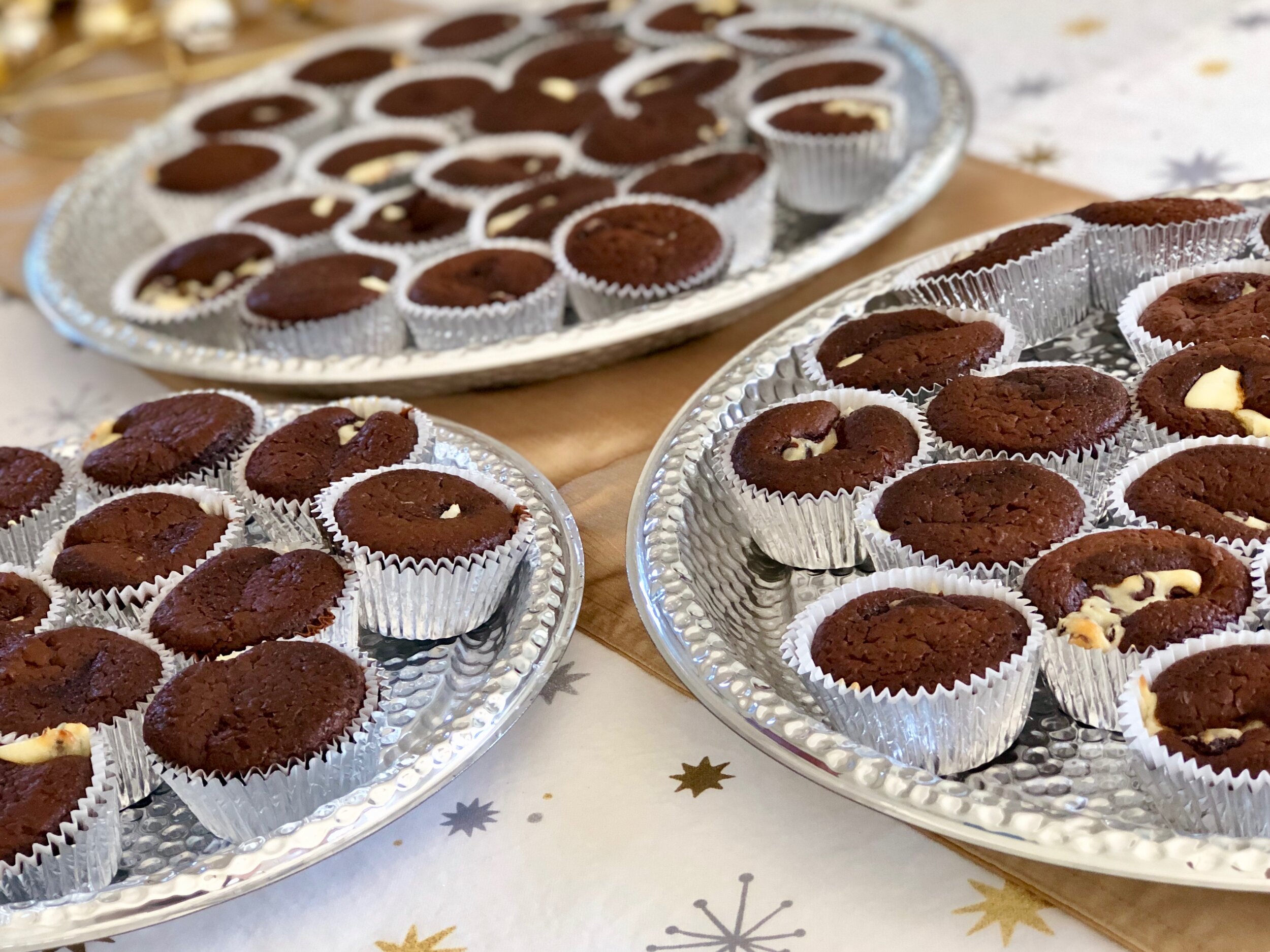 3 trays of chocolate cupcakes filled with cream cheese filling and chocolate chips