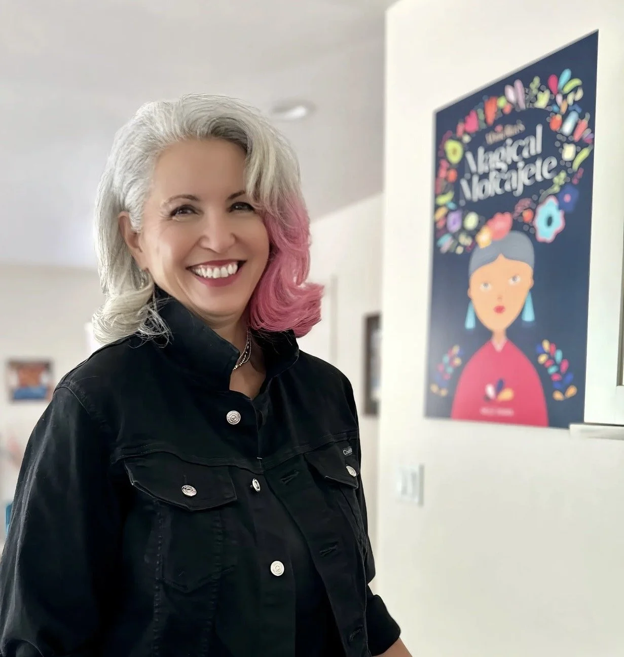 Diana Silva standing in her kitchen, smiling broadly wearing a black jacket