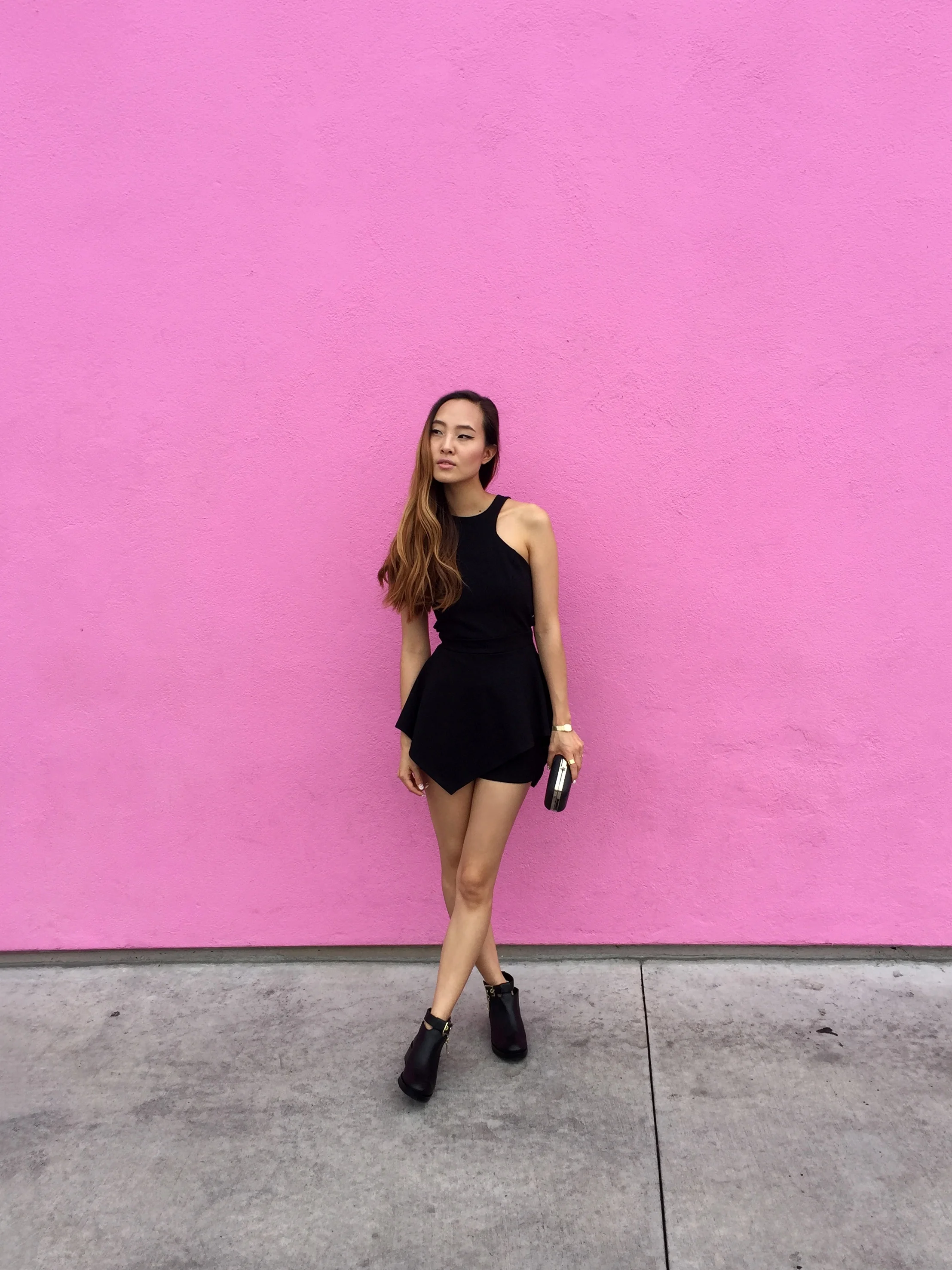 At the pink Paul Smith store wearing a r omper by Nasty Gal, b ooties by Zara, and s unglasses by Urban Outfitters.