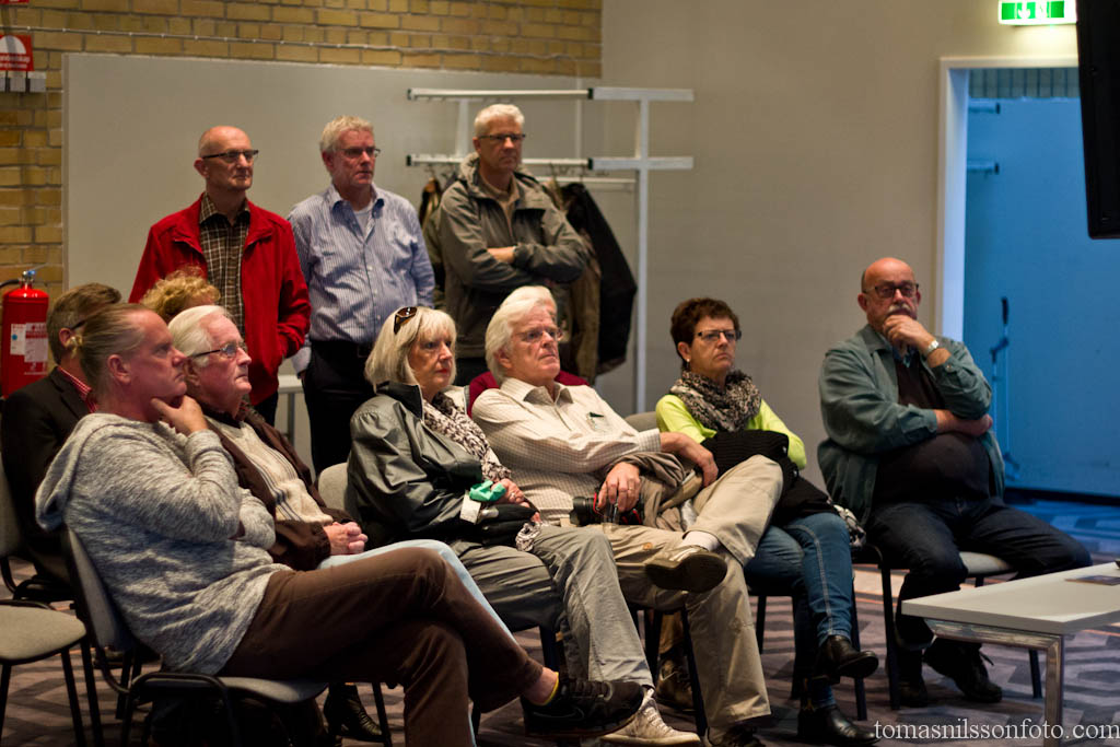 Audience members watching accepted images in the color section on a big screen TV