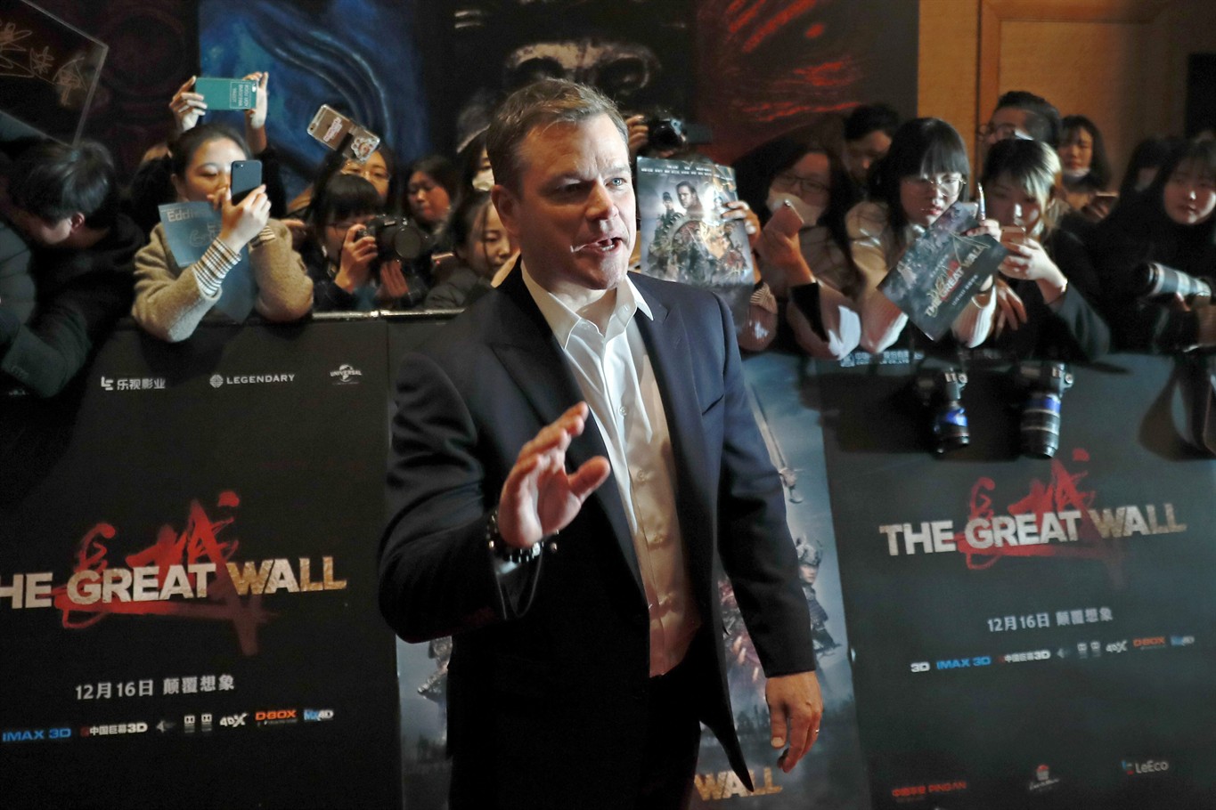 Actor Matt Damon gestures in front of Chinese fans as he arrives at a red carpet event for the movie "The Great Wall" at a hotel in Beijing, Tuesday, Dec. 6, 2016. (AP Photo/Andy Wong)