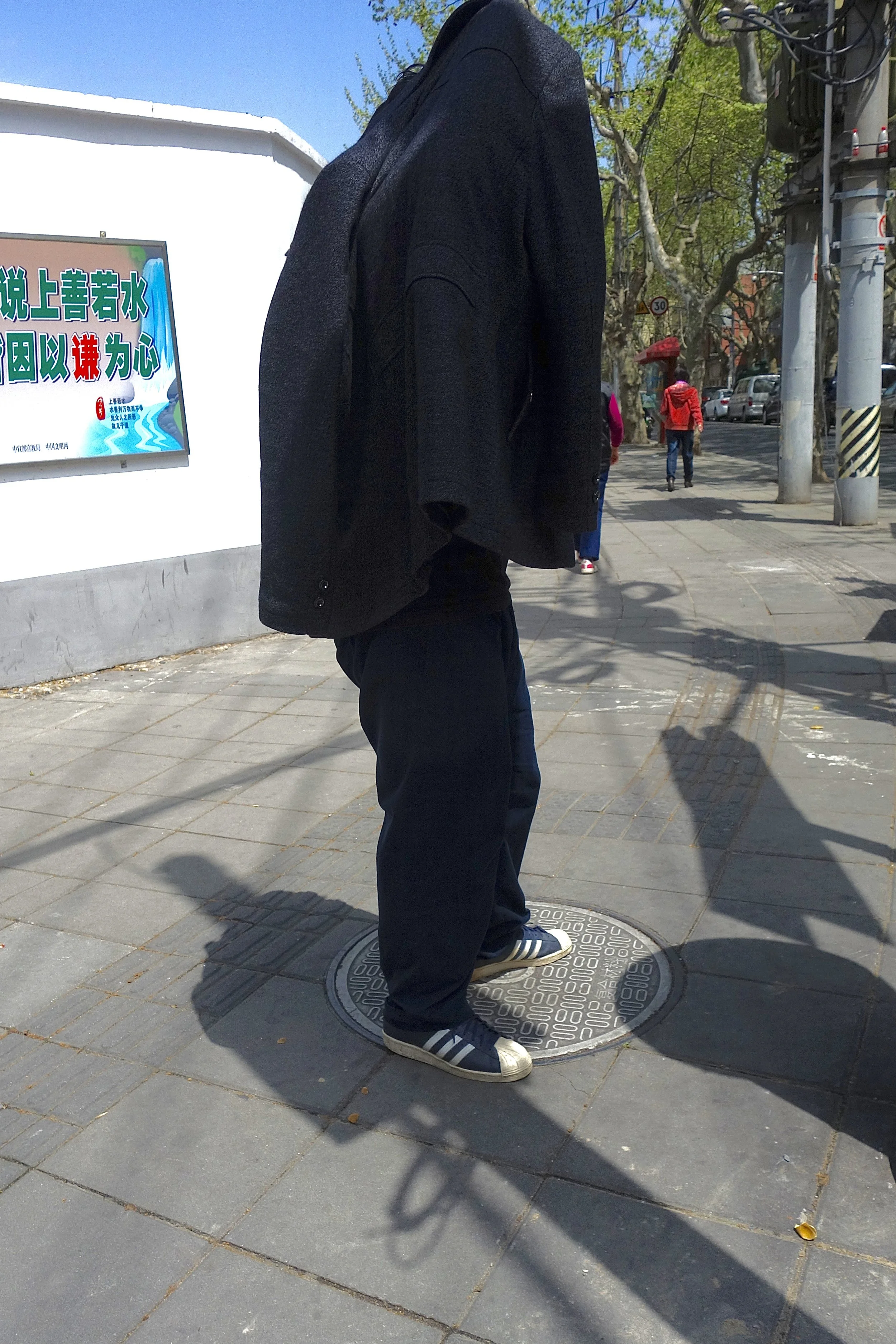 MAN STANDING ON A MANHOLE