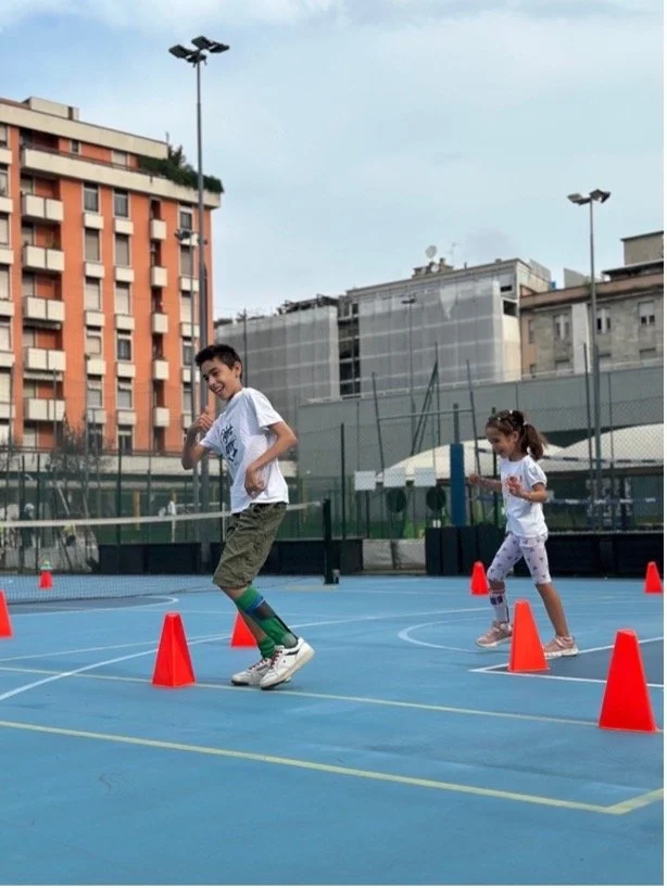 Questa foto scattata nell’edizione 2025 del Fight Camp a Milano rappresenta Mario, a sinistra, nella sua prima esperienza sperimentale da Junior Tutor di Beatrice, a destra, entrambi ripresi durante un percorso sportivo