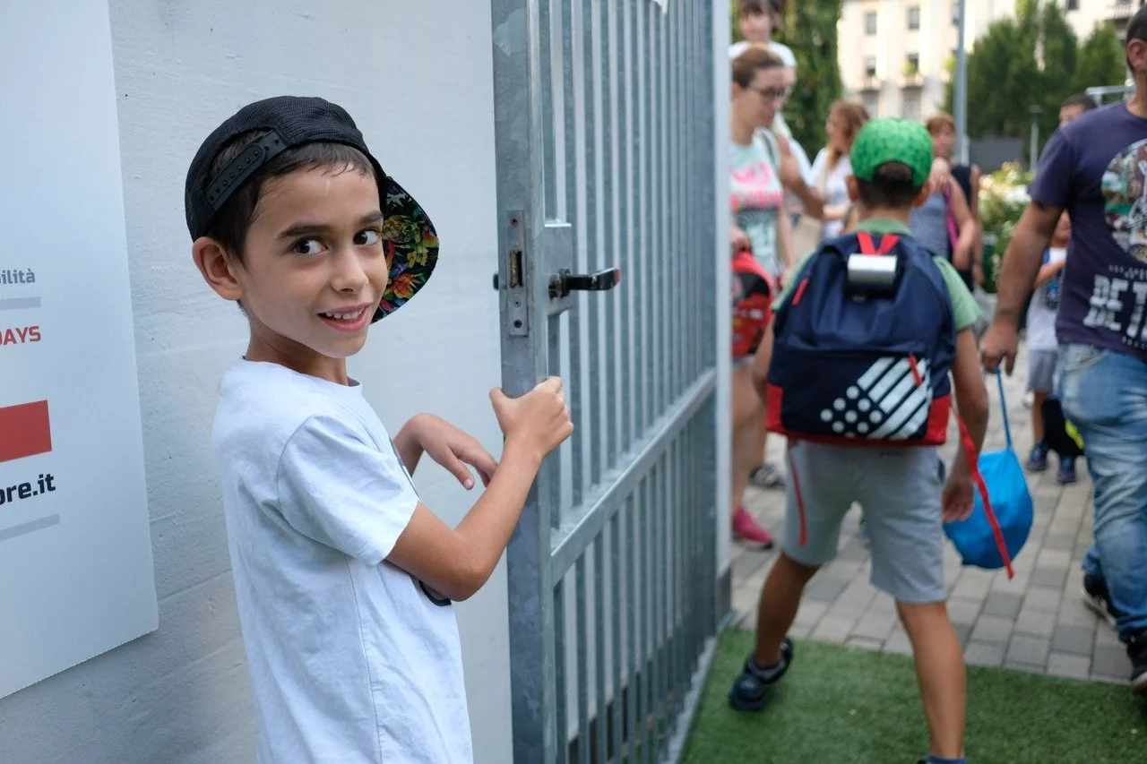 Questa foto scattata da Eleonora Rettori a Milano, rappresenta Mario, il presidente onorario della Fondazione Fightthestroke, che apre il cancello per far entrare i bambini dell’edizione Fight Camp 2019