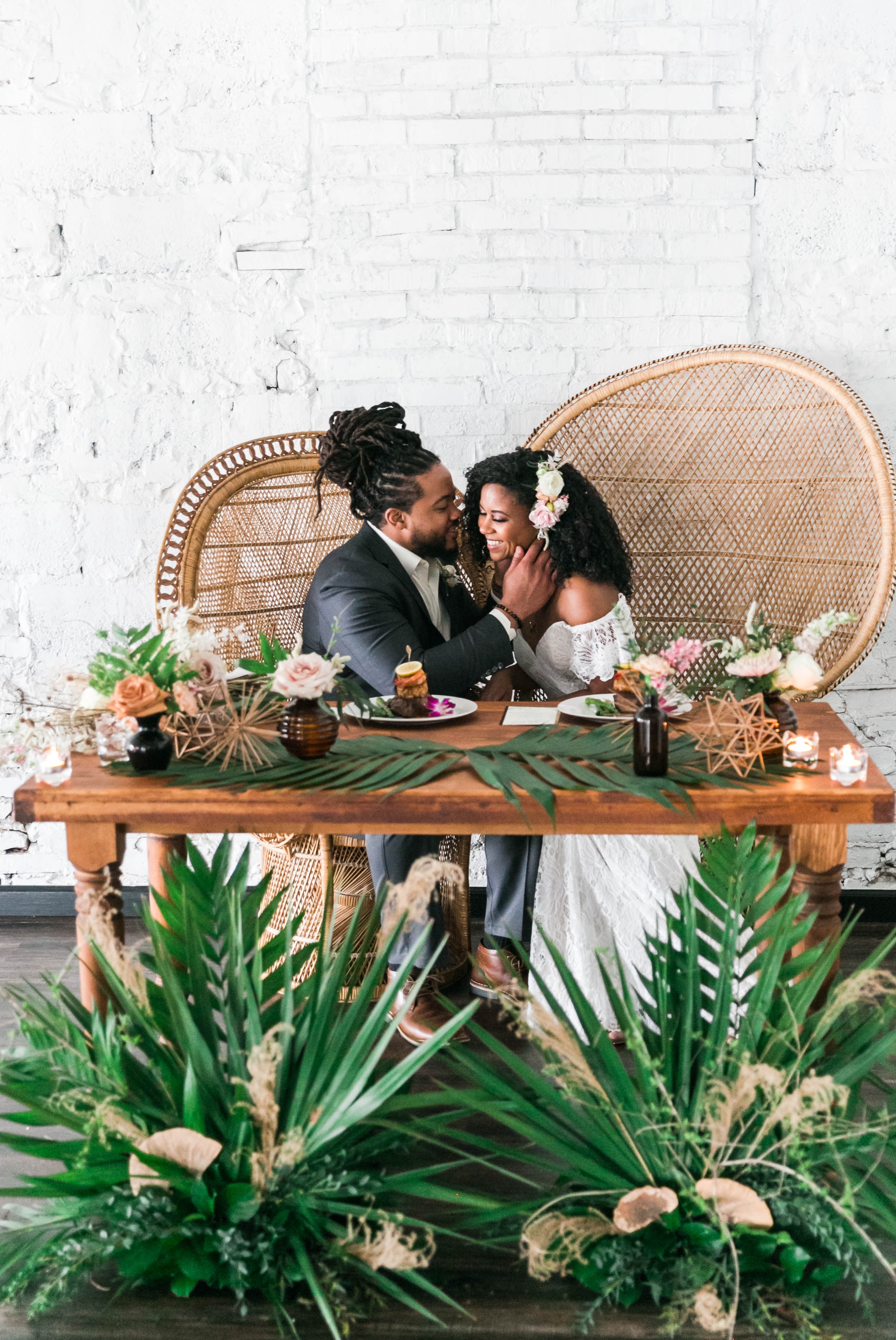  Bride and groom at the sweetheart table at their wedding reception sitting in Midcentury Woven Wicker Peacock Chairs - Black Love - Tropical Destination Wedding Inspiration - Oahu Hawaii Wedding Photography 