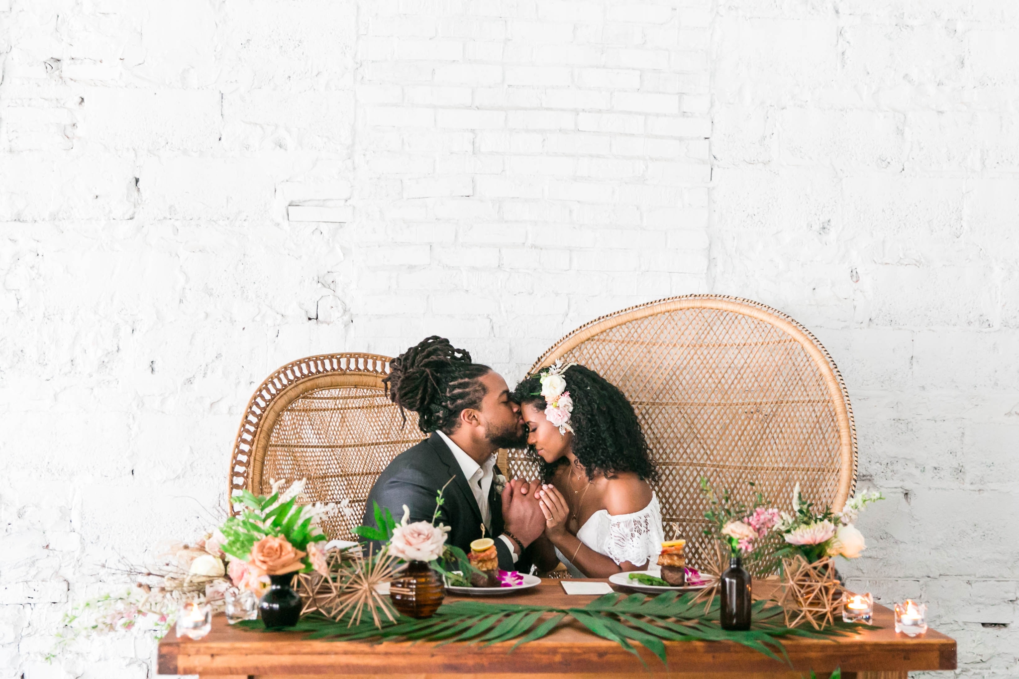  Bride and groom at the sweetheart table at their wedding reception sitting in Midcentury Woven Wicker Peacock Chairs - Black Love - Tropical Destination Wedding Inspiration - Oahu Hawaii Wedding Photography - indoor natural light photographer 