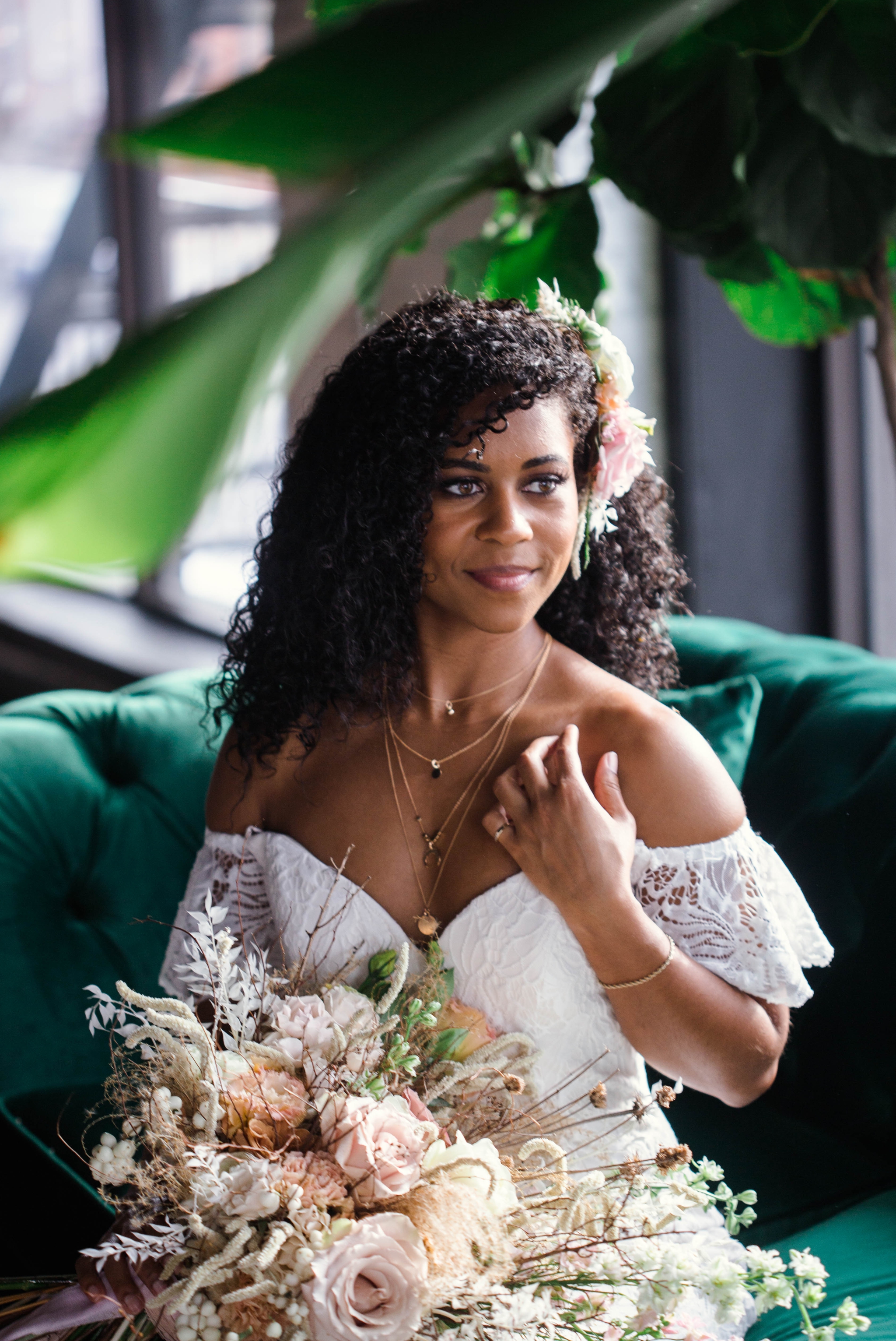  Indoor Natural light portrait of a black bride in a boho wedding dress sitting on an emerald tufted sofa - flowers in natural african american hair - oahu hawaii wedding photographer 
