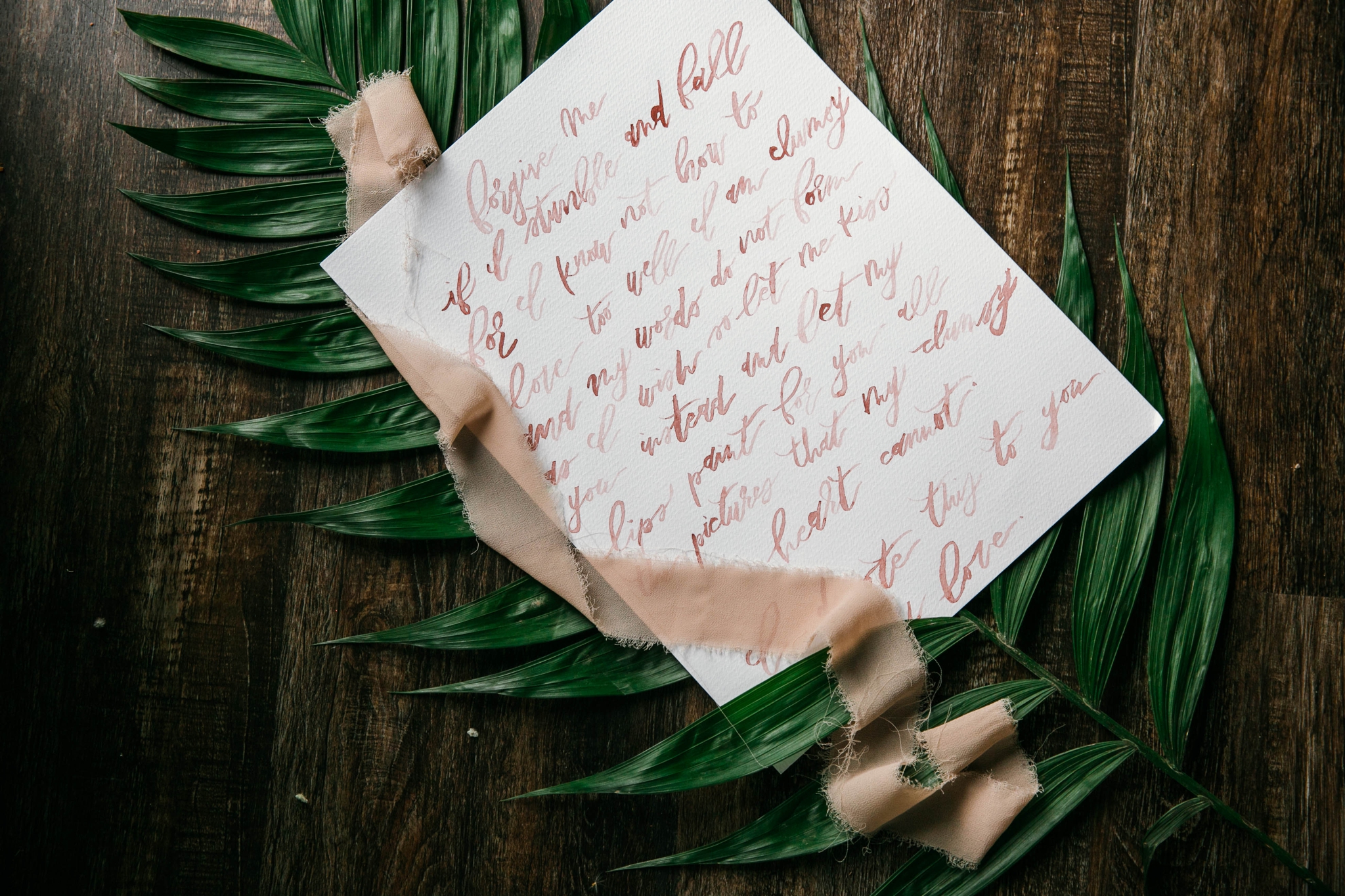  Lay flat of Wedding Vows with a tropical leave as the background with light pink ribbon styled by Johanna Dye Photography designed by Tortoise.Design - Oahu Hawaii Wedding Photographer 